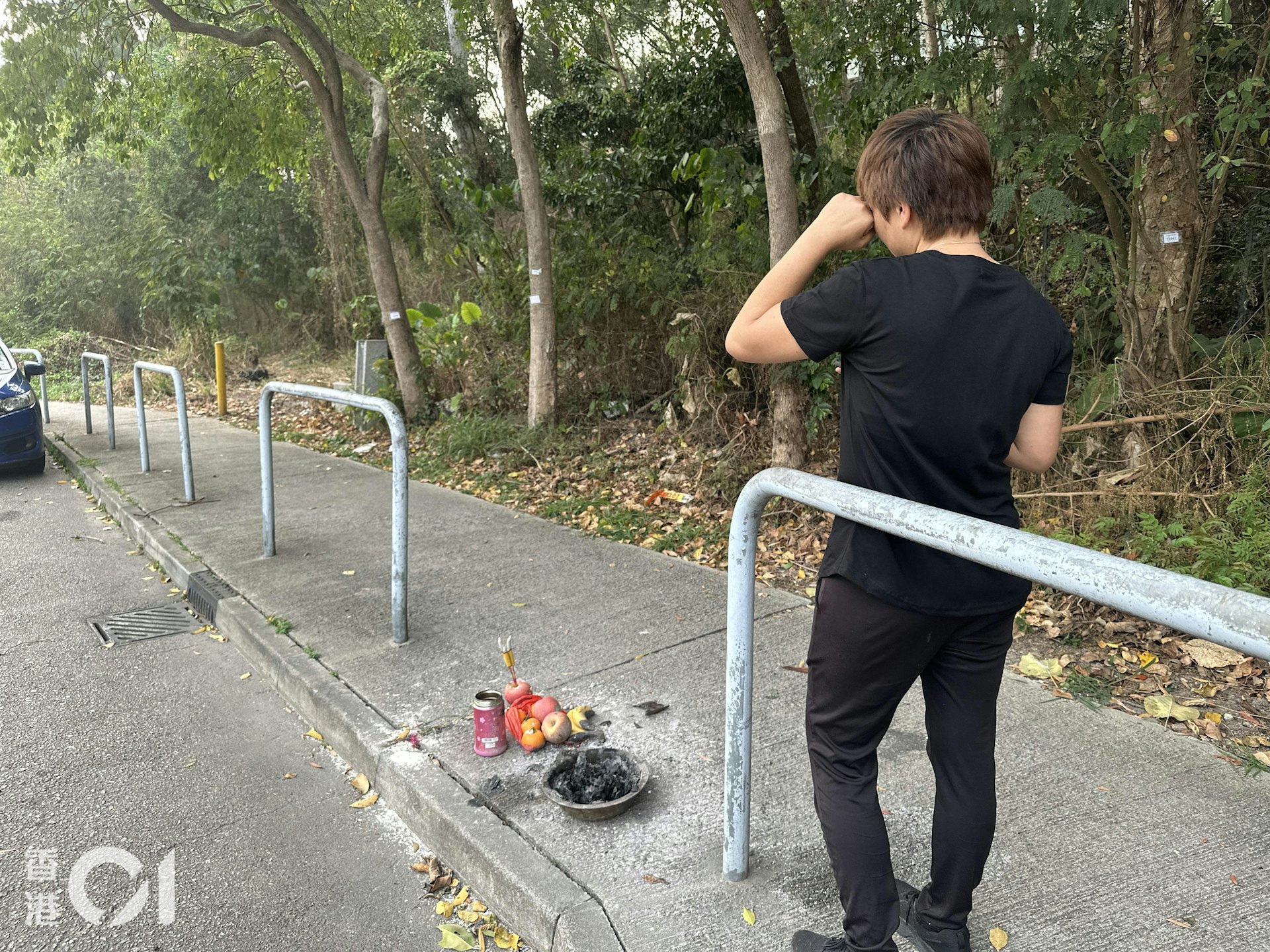 71歲姓胡老翁在元朗大棠路遭的士撞斃,其女兒胡女士返回現場拜祭時痛哭落淚。(王譯揚攝)