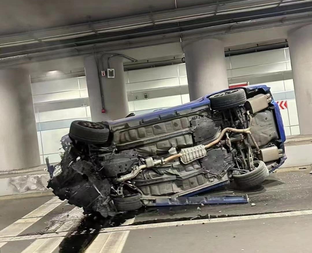 一辆挂着香港车牌的蓝色「扫把佬（Subaru）」10.5代翻侧，车头严重损毁，碎片散落一地。