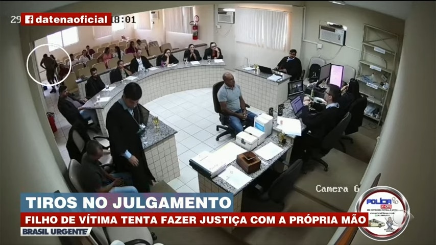 受害人儿子（白圈者）在旁听审判期间，于后座掏出手枪，意图袭击被告。（YouTube截图 / @Brasil Urgente）