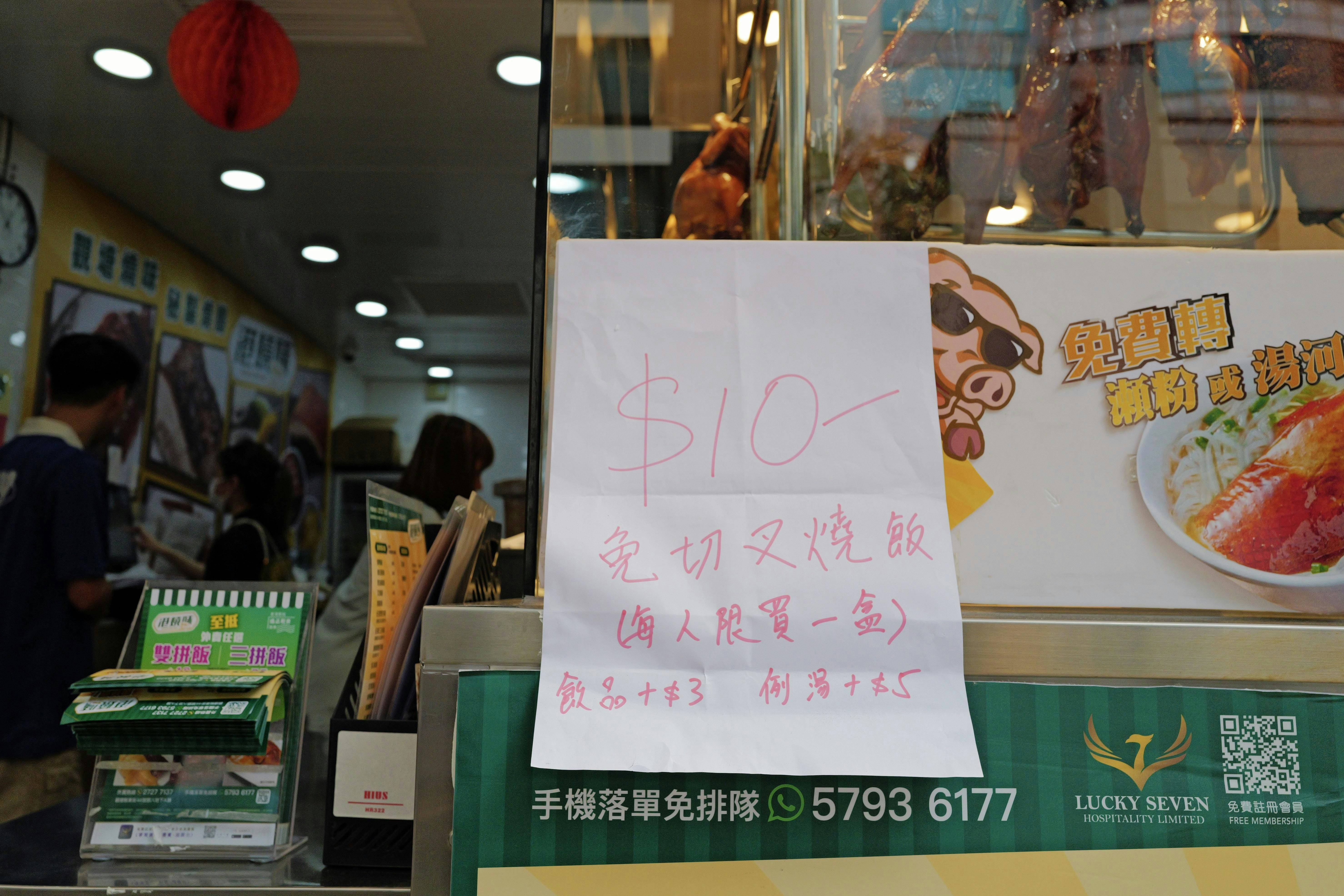 店铺外继续贴上手写宣传公告，标明卖10元一盒免切叉烧饭。（欧嘉乐摄）