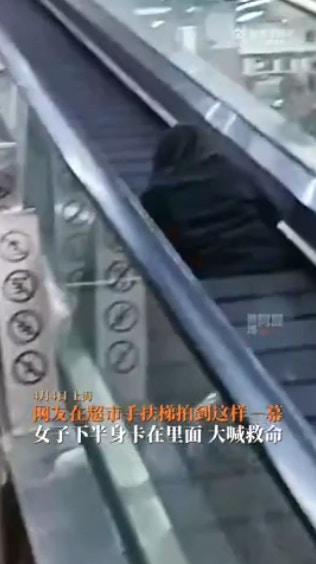 影片画面显示，女子一脚踏进正在运行的扶手电梯，没想到底下竟空了一块，导致女子整个下半身都陷进去动弹不得。（截图）