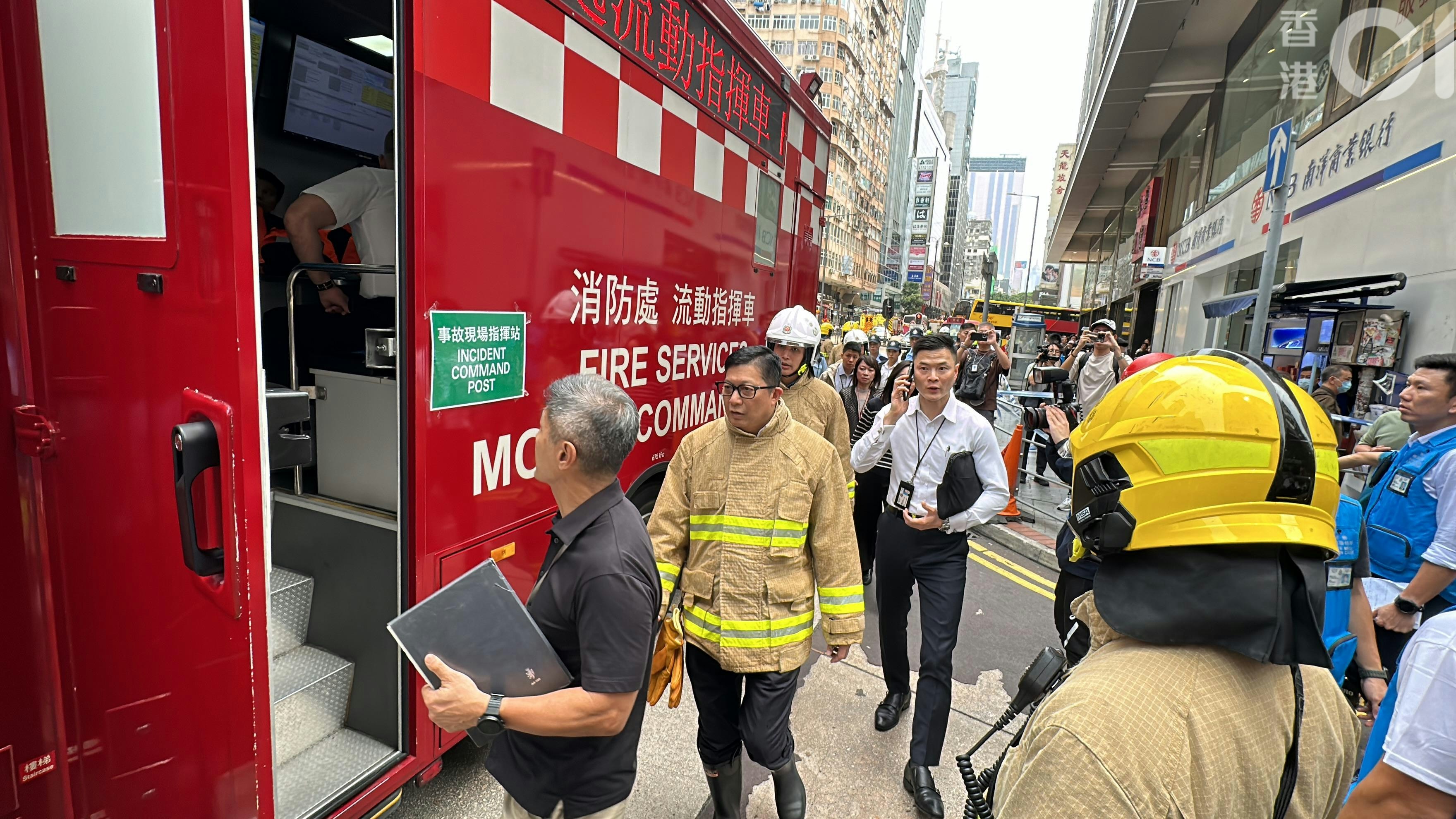 保安局局长邓炳强到现场视察，并登上消防处流动指挥车了解详情，其后换上消防制服佩戴消防帽进入火场。（马耀文摄）