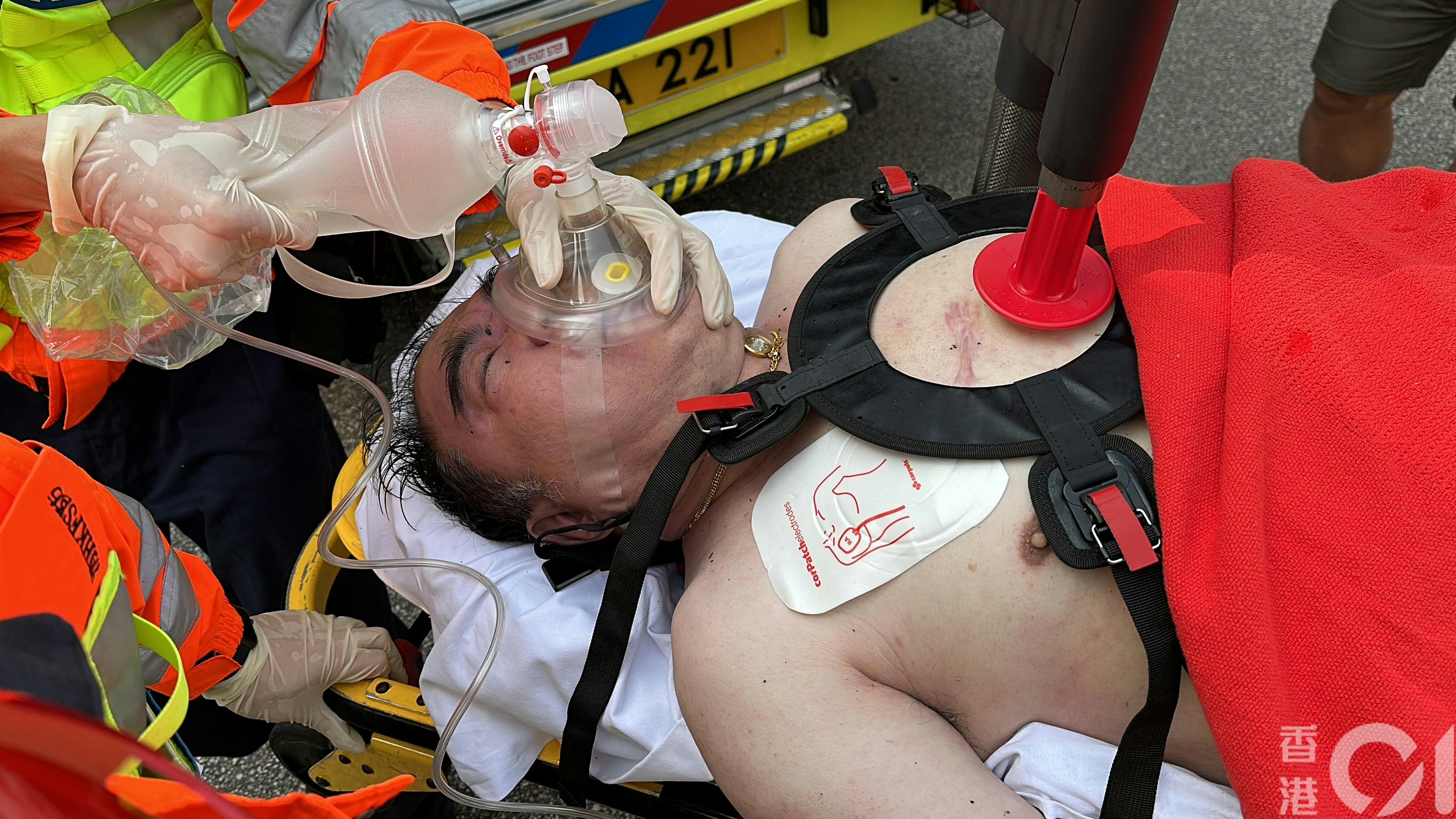 一名男子伤势严重送院，救护员用自动心外压机为他急救。（黄学润摄）