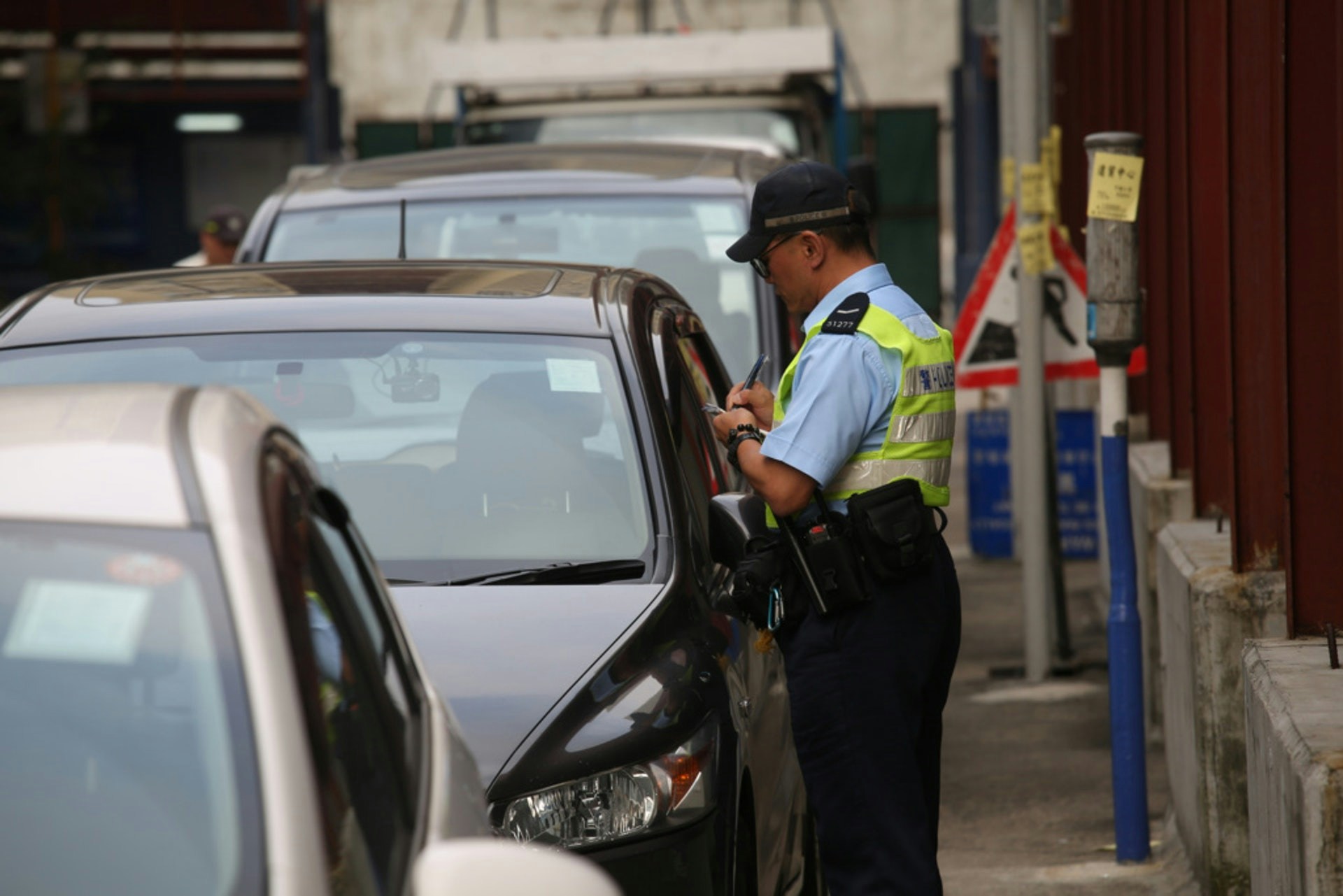 司機見到警員正在抄牌，於是走近求情，但警員反指司機「𠵱家泊喺雙黃線」，在限制區上落車比一般違例泊車更嚴重。（示意圖/資料圖片 / 魯嘉裕攝）