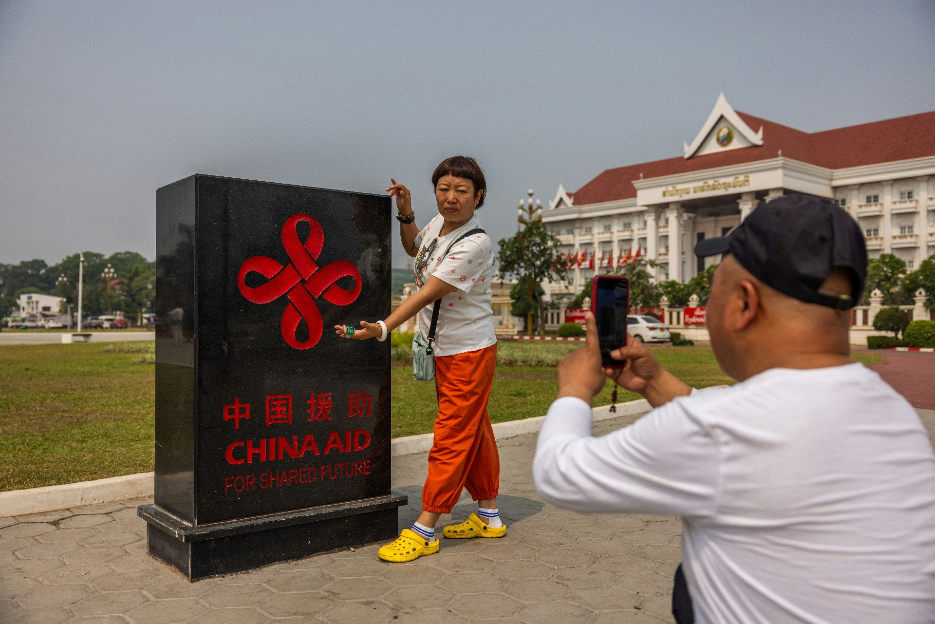 4月8日，老撾萬象，中國遊客在一塊紀念碑前拍照留念。（Lauren DeCicca/Getty Images）