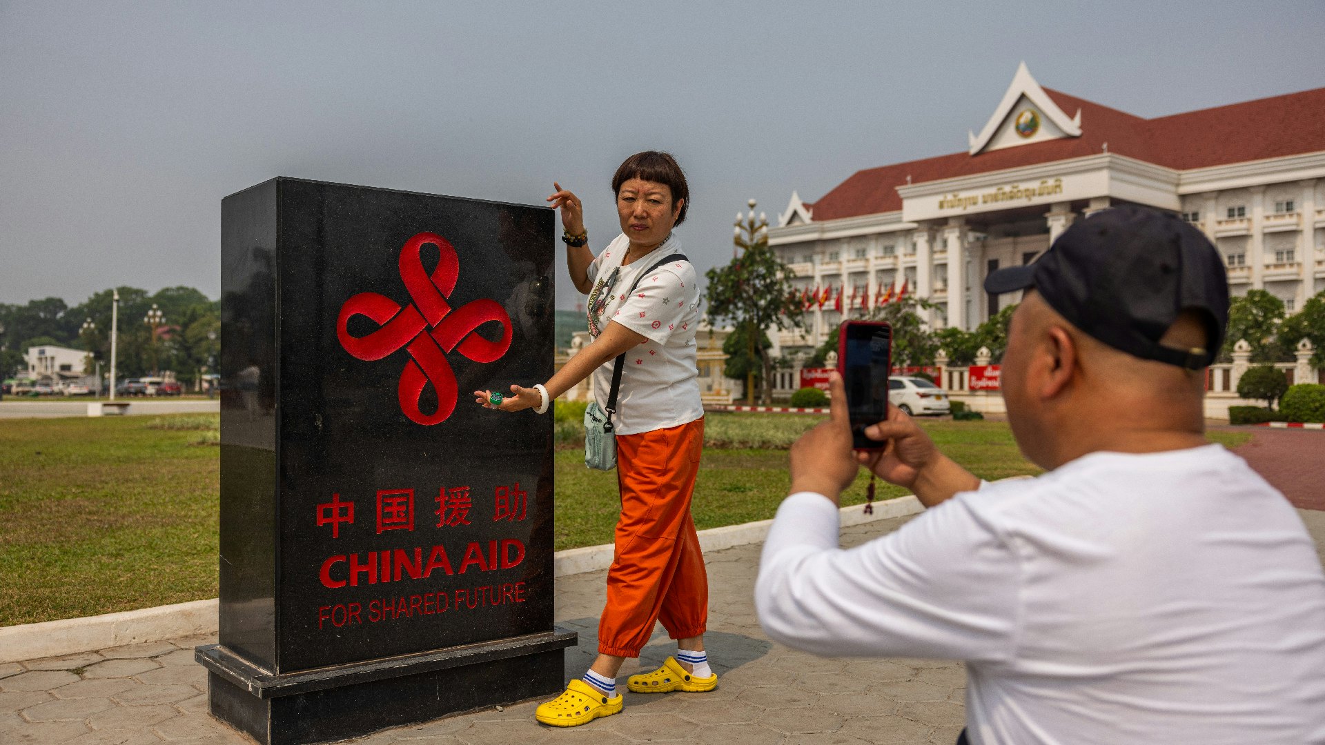 4月8日，老撾萬象，中國遊客在一塊紀念碑前拍照留念。（Lauren DeCicca/Getty Images）