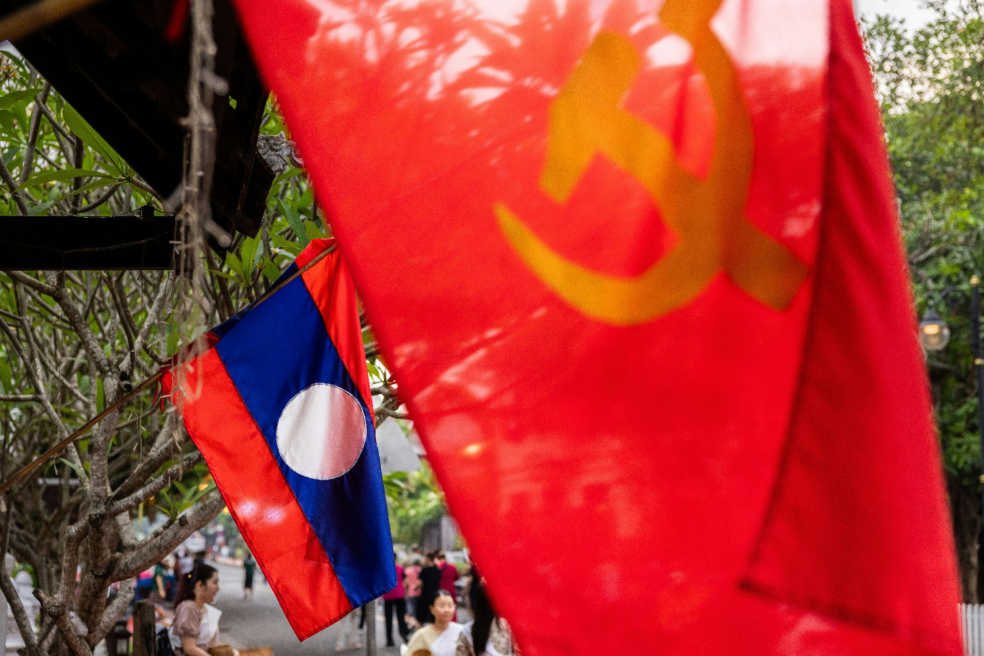 4月11日，老撾龍坡邦，商店外掛着老撾國旗及共產黨旗。老撾現在的執政黨「老撾人民革命黨」亦是奉行共產主義的政黨。（Lauren DeCicca/Getty Images）