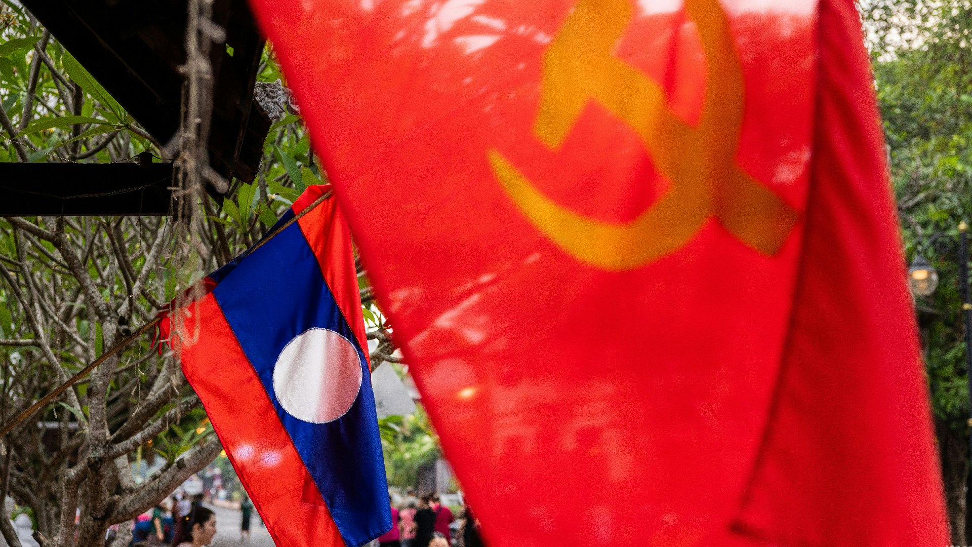 4月11日，老撾龍坡邦，商店外掛着老撾國旗及共產黨旗。老撾現在的執政黨「老撾人民革命黨」亦是奉行共產主義的政黨。（Lauren DeCicca/Getty Images）