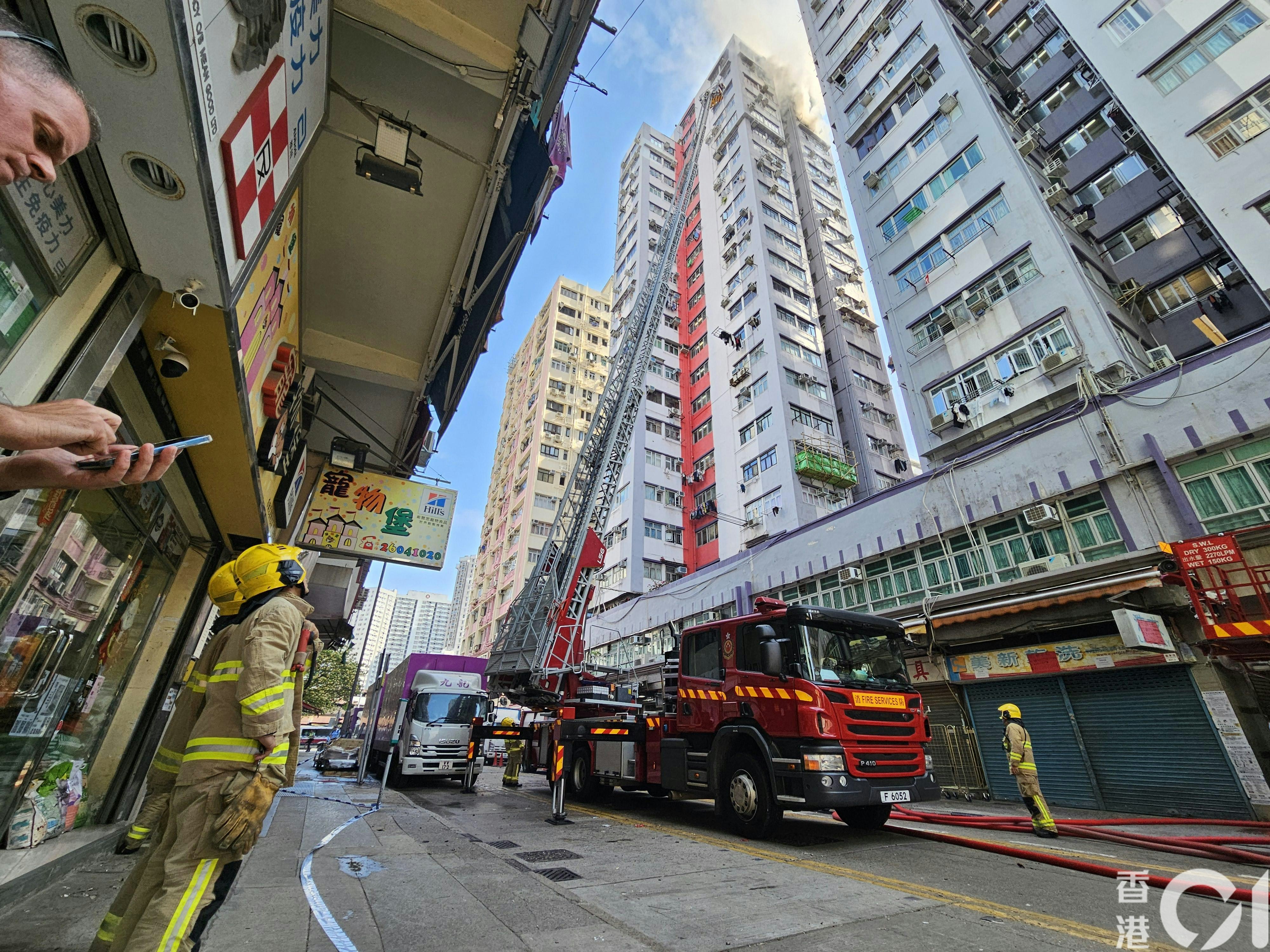 金华大厦高层单位冒出浓烟，消防派遣烟帽队到场，拖喉灌救。（梁伟权摄）
