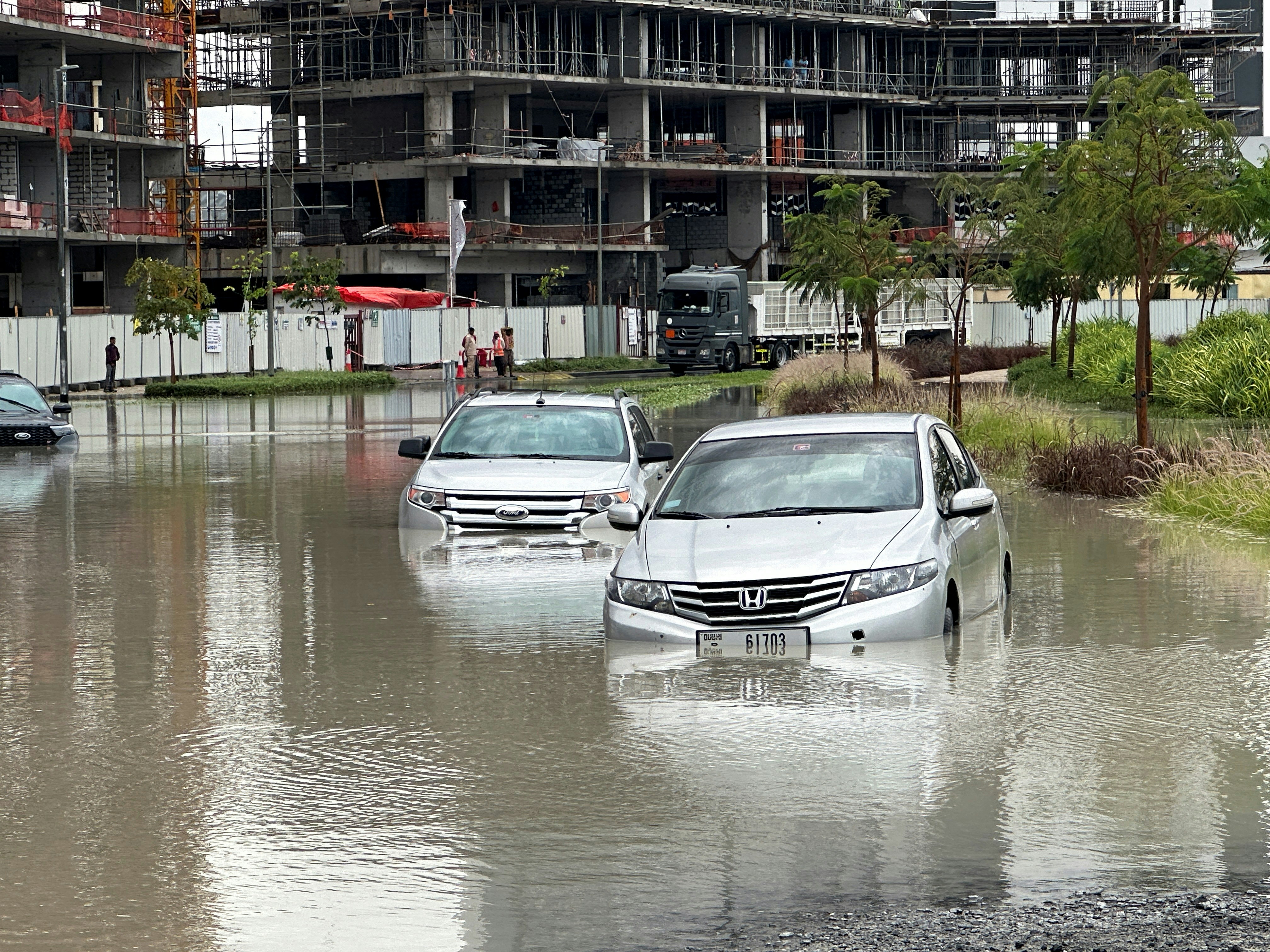 2024年4月16日，阿联酋杜拜在暴风雨过后受灾，汽车驶过被洪水淹没的街道。（Reuters）