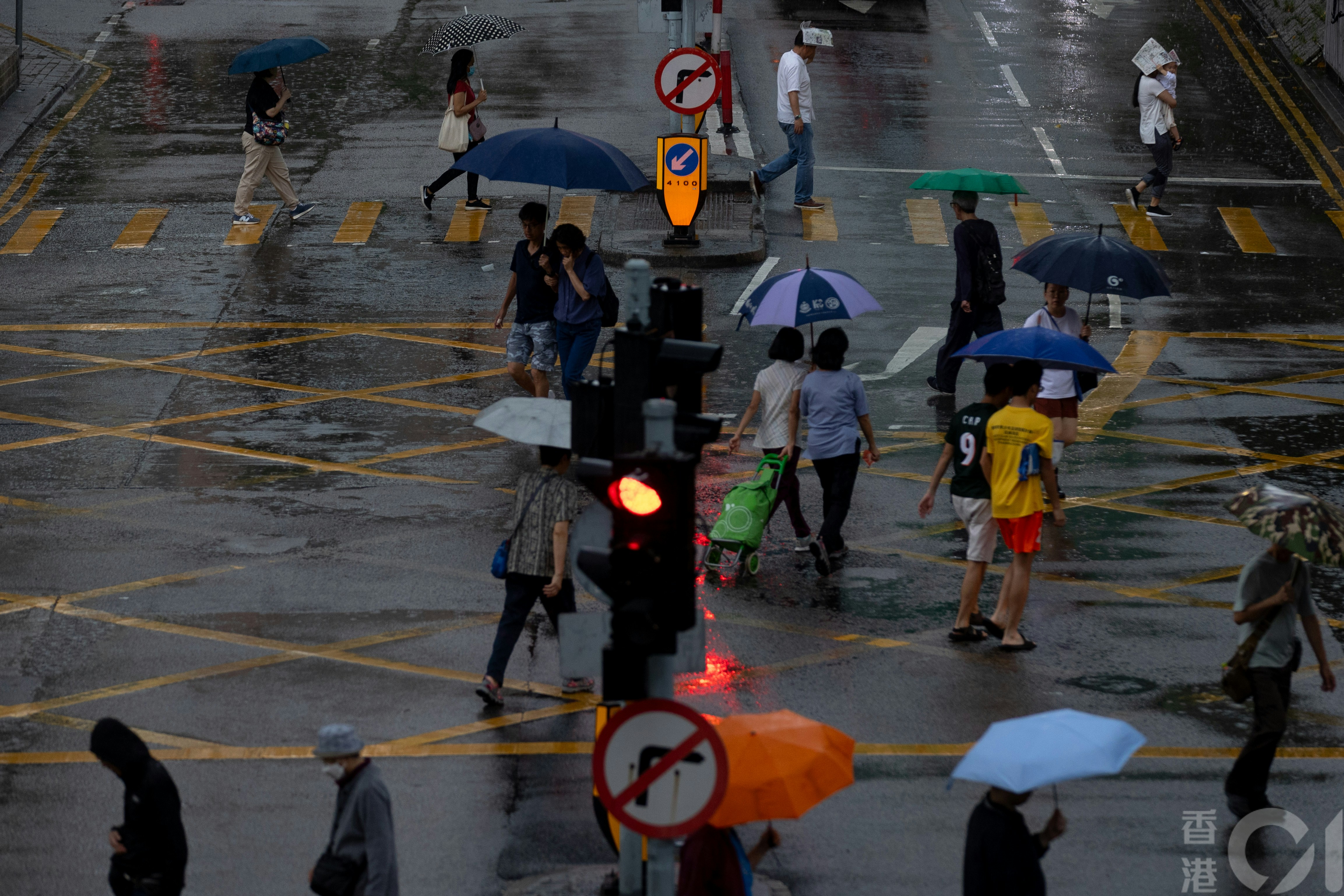 天文台4月21日早上发出黄色暴雨警告，在大埔，出街市民在风雨中而行。（夏家朗摄）