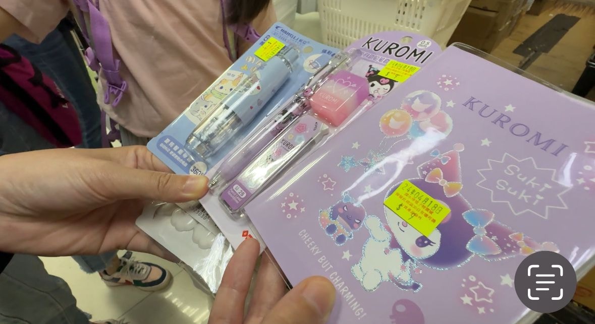 林女士拿出女儿的战利品，有日本卡通人物做封面的笔记簿、铅芯笔、擦胶笔等，均只售数元。（王海图摄）