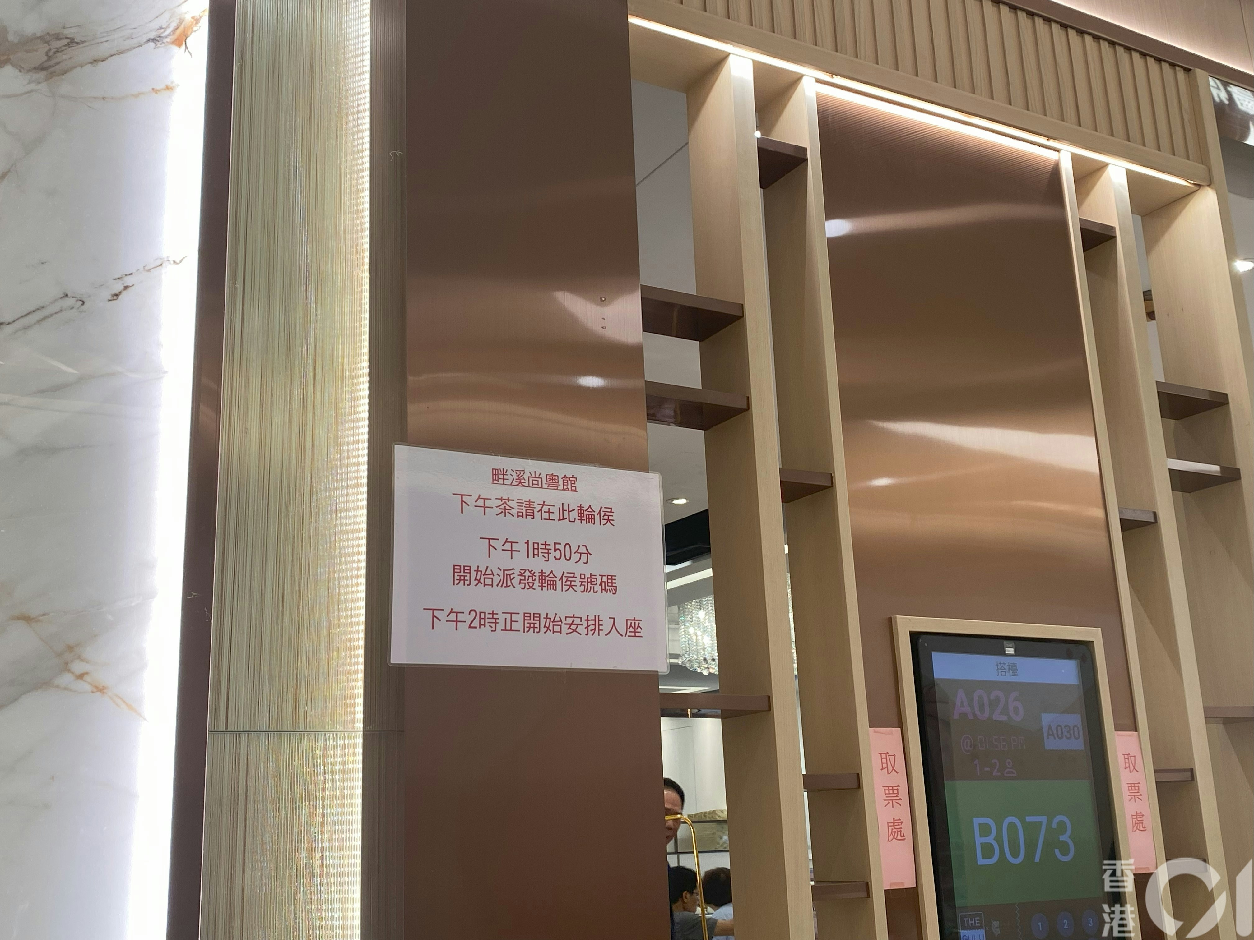 4月21日东港城畔溪尚粤馆外已经取筹的顾客表示已等候约15分钟，形容筹号「一个都没动」，不过仍打算继续等候。（余月明摄）