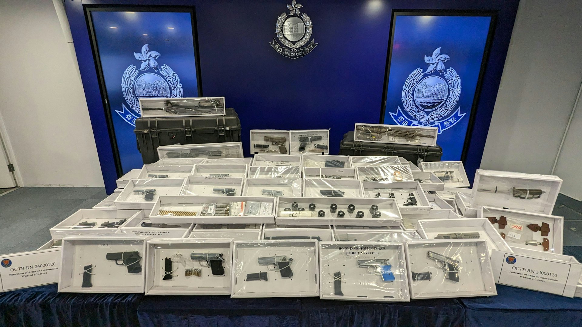 有組織罪案及三合會調查科於沙田區一個迷你倉內搜獲一批武器,包括18支手槍、超過100發不同口徑的子彈、超過100件槍械元件、1支電槍、11把刀及4把匕首。(黃偉民攝) 有組織罪案及三合會調查科於沙田區一個迷你倉內搜獲一批武器,包括18支手槍、超過100發不同口徑的子彈、超過100件槍械元件、1支電槍、11把刀及4把匕首。(黃偉民攝)