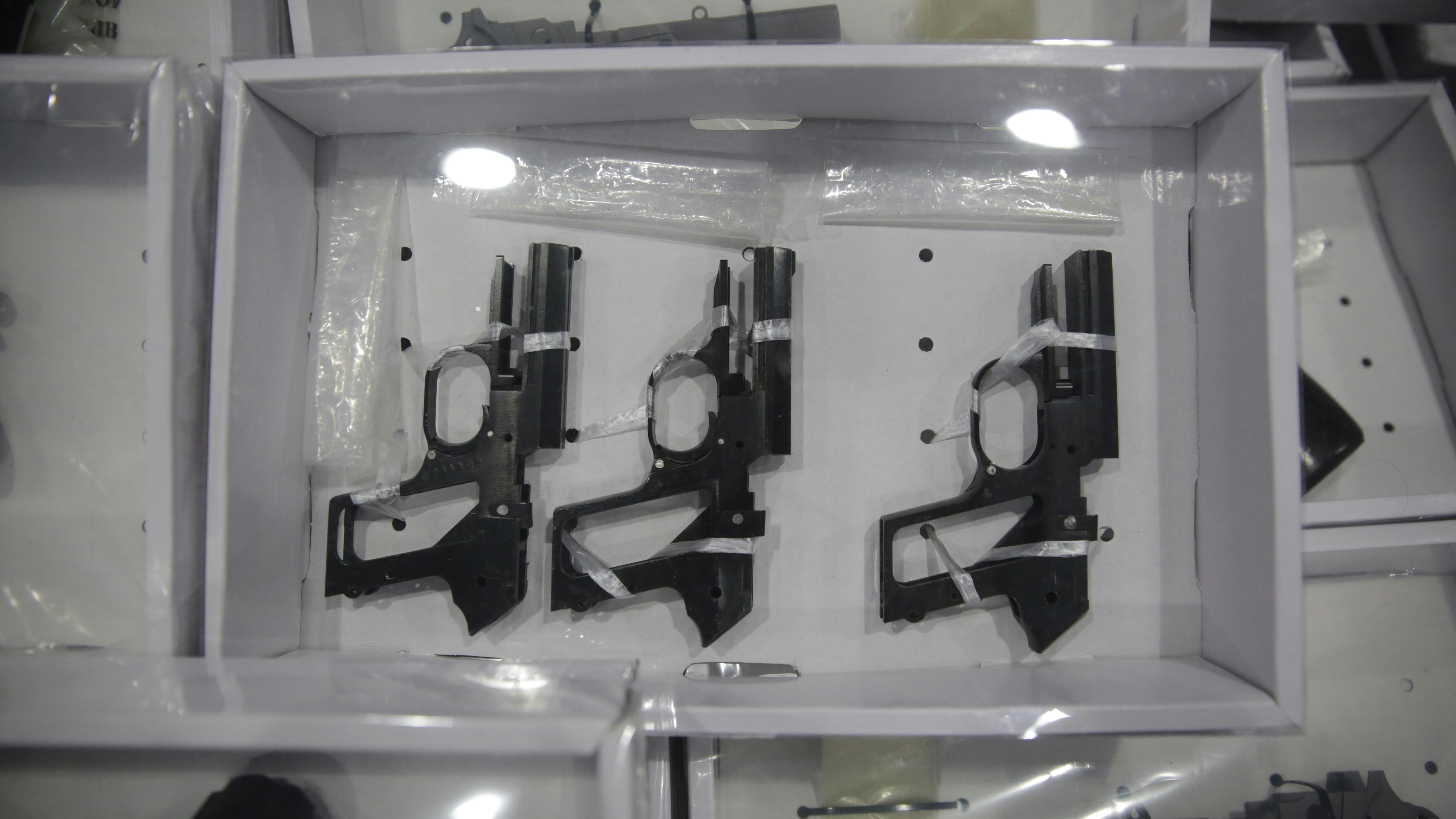 有组织罪案及三合会调查科于沙田区一个迷你仓内搜获一批武器，包括18支手枪、超过100发不同口径的子弹、超过100件枪械元件、1支电枪、11把刀及4把匕首。（黄伟民摄）