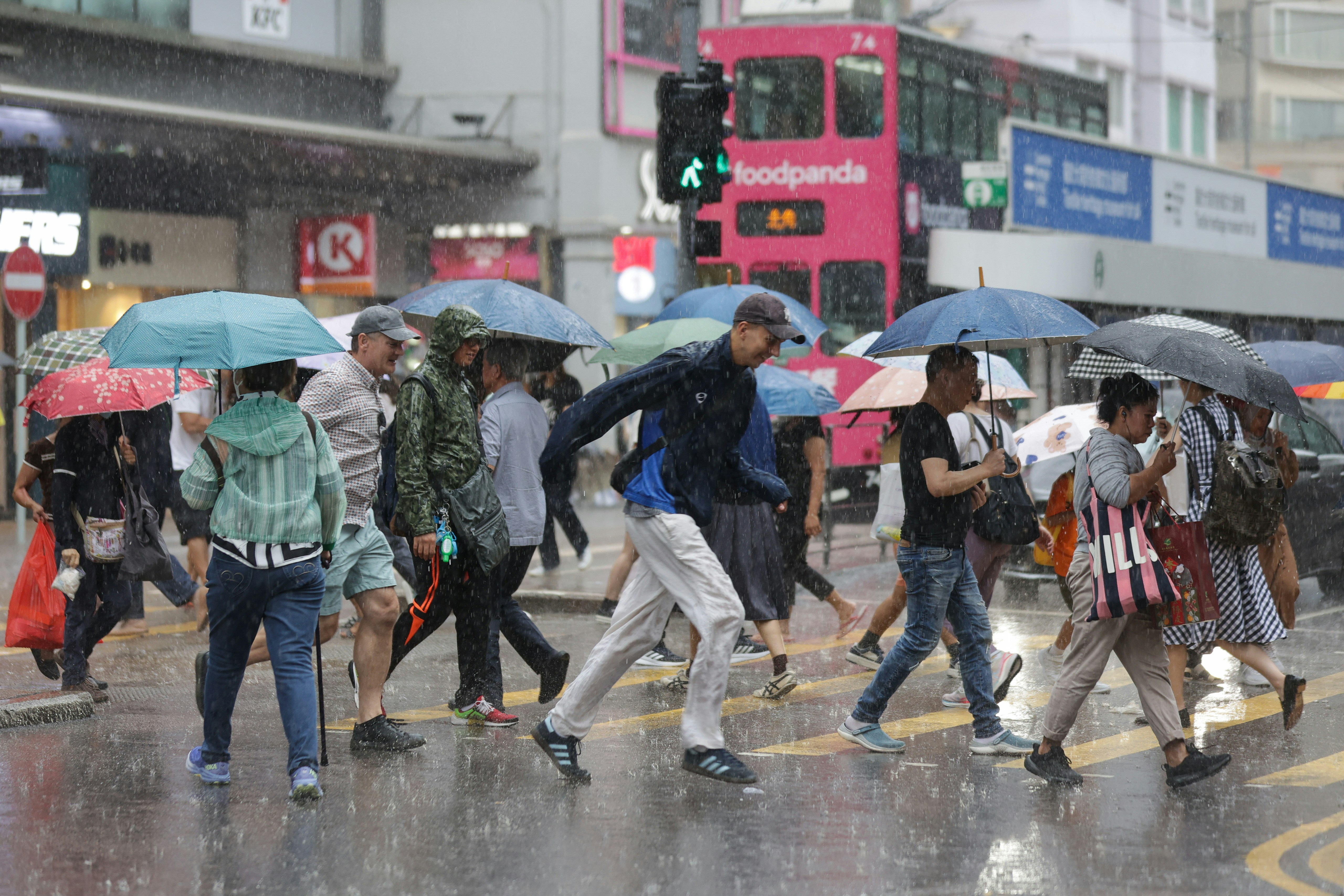 今日（28日）有骤雨，在港岛市民都早有准备，但亦有未带备雨具人士，急步过马路。（苏炜然摄）