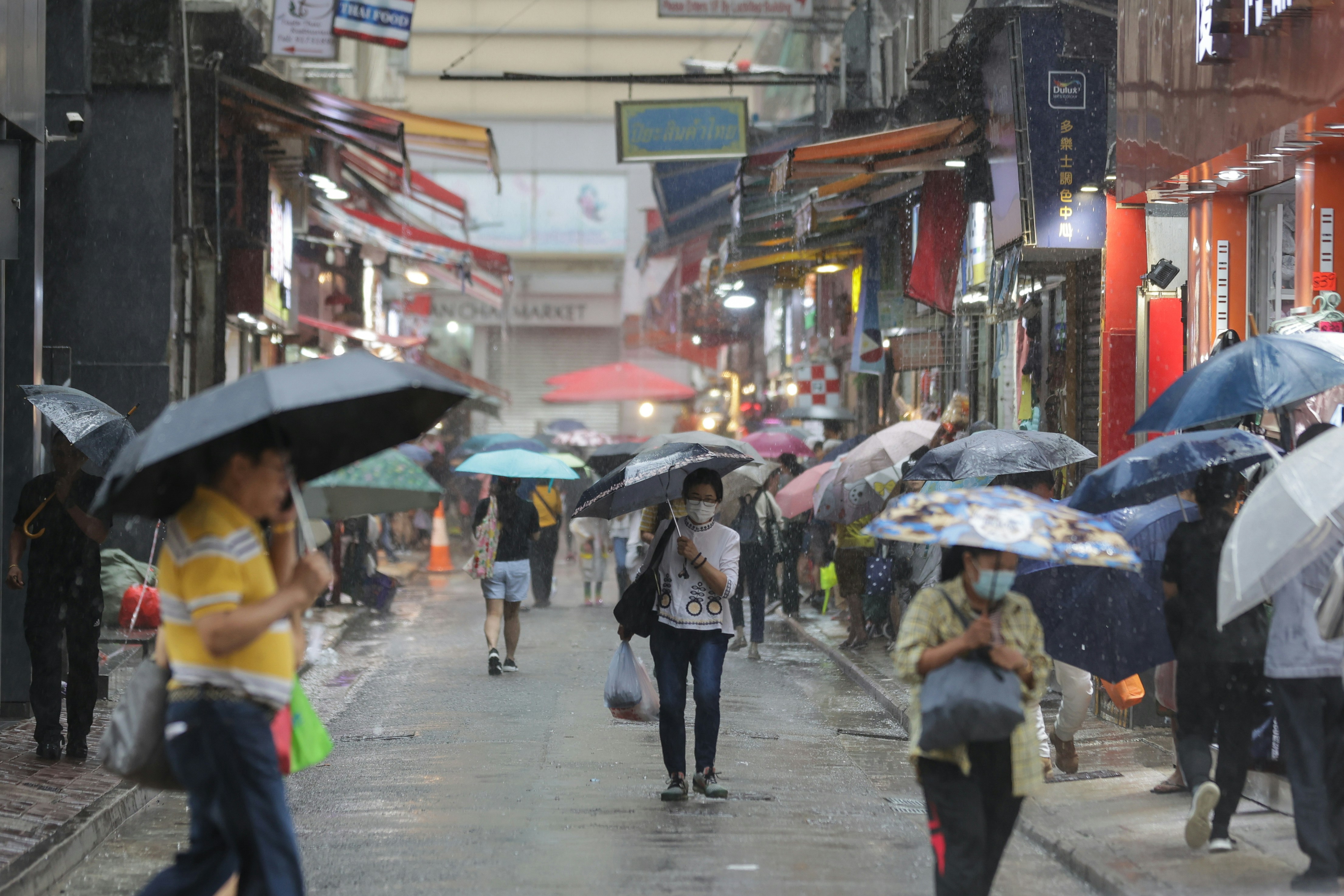 今日（28日）有骤雨，在港岛市民都早有准备，但亦有未带备雨具人士，急步过马路。（苏炜然摄）