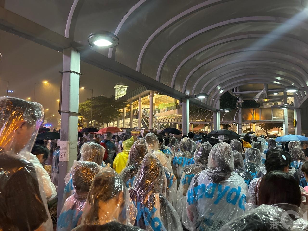 强雷雨区晚上近10时移至中环一带，在中环海滨听五月天演唱会的歌迷，急急避雨。（吴美松摄）