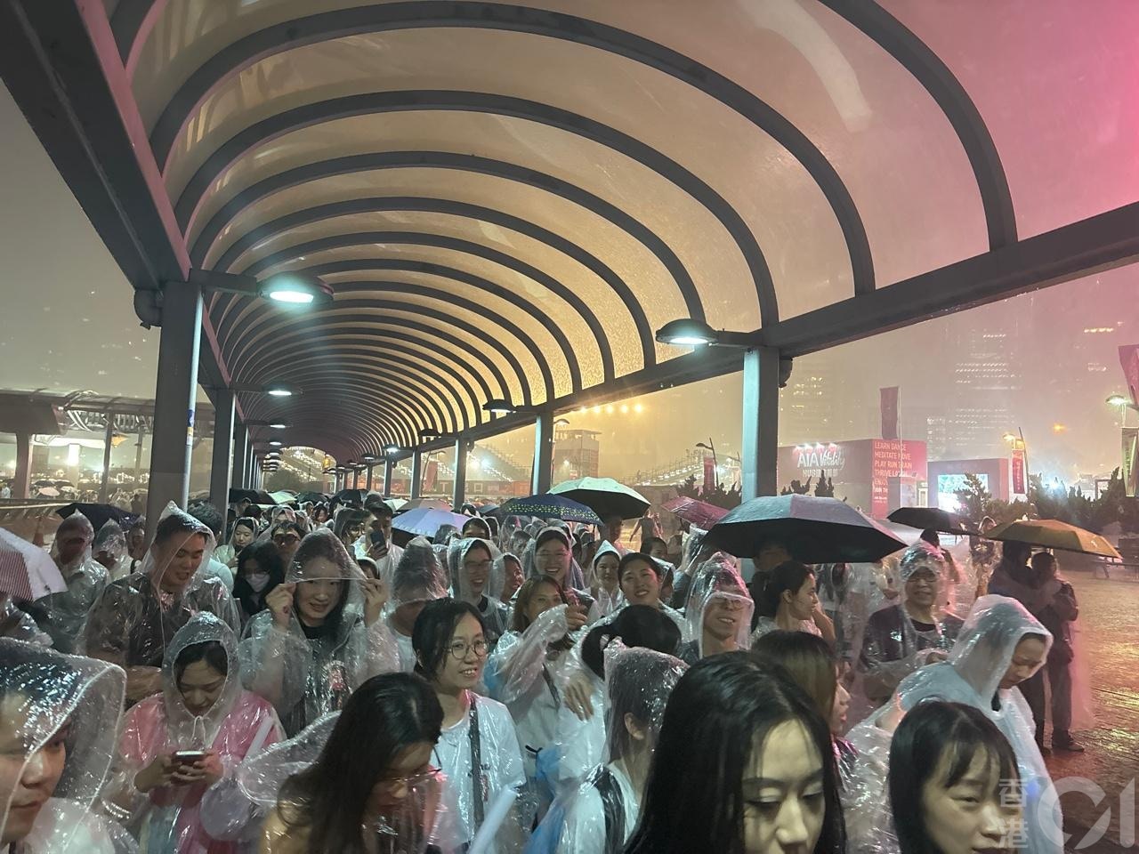 强雷雨区晚上近10时移至中环一带，在中环海滨听五月天演唱会的歌迷，急急避雨。（吴美松摄）