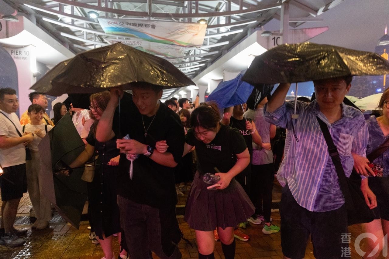 强雷雨区4月30日晚上近10时移至中环一带，在中环海滨举行的五月天演唱会宣布腰斩，歌迷急急避雨。（廖雁雄摄）