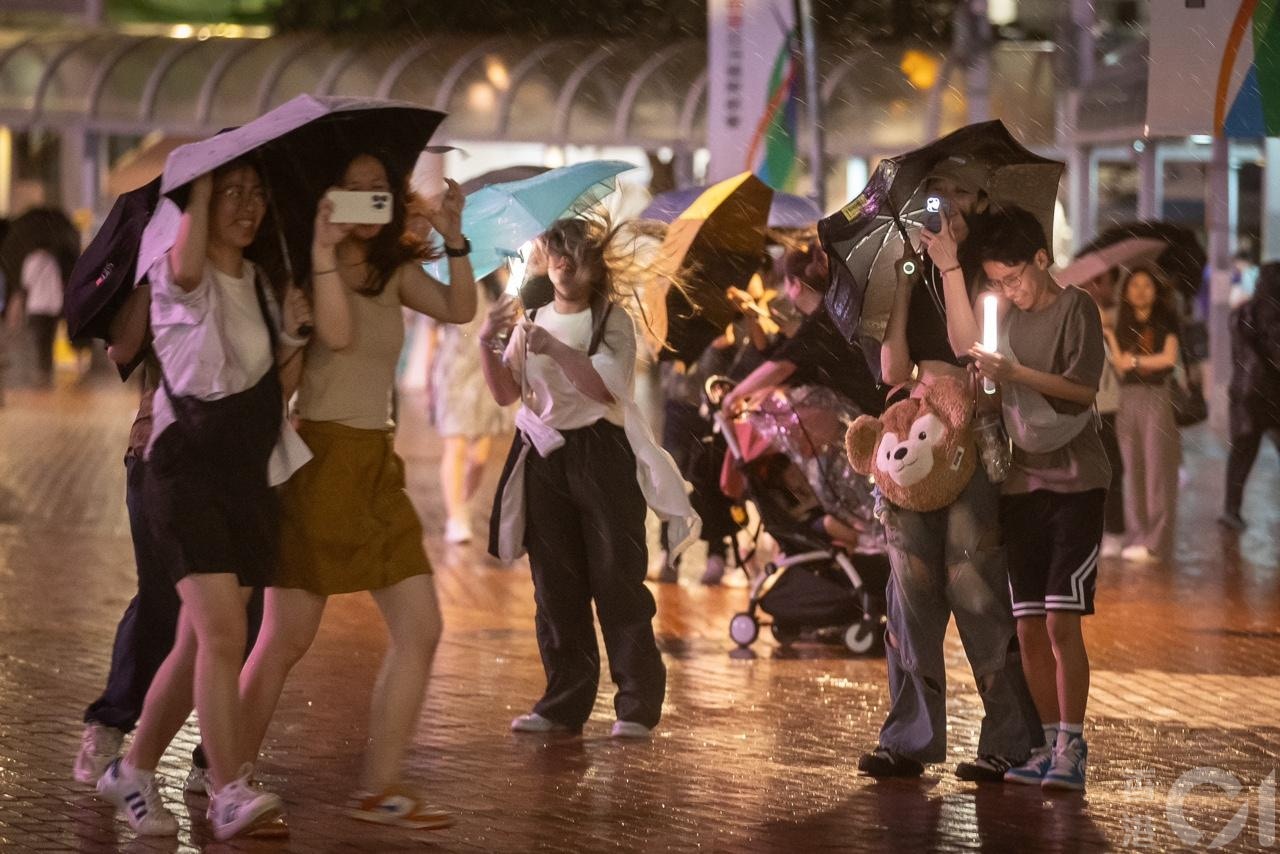 强雷雨区4月30日晚上近10时移至中环上空，在中环海滨举行的五月天演唱会宣布腰斩，歌迷急急避雨，风雨下显得十分狼狈。（廖雁雄摄）