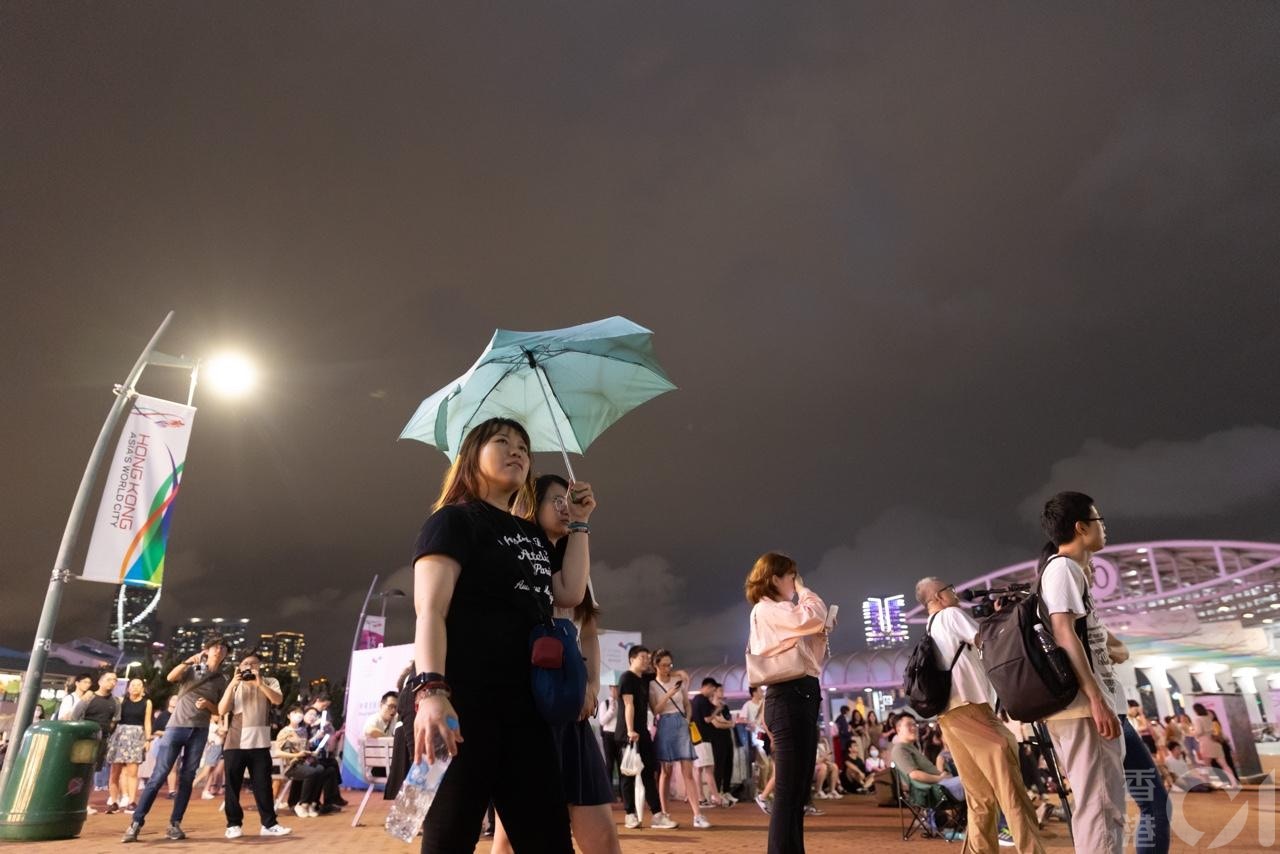 五月天4月30日晚上在中环海滨举行演唱会，在强雷雨区近10时来临前，有市民在海傍打卡、散步或做运动，并感受演唱会气氛。（廖雁雄摄）
