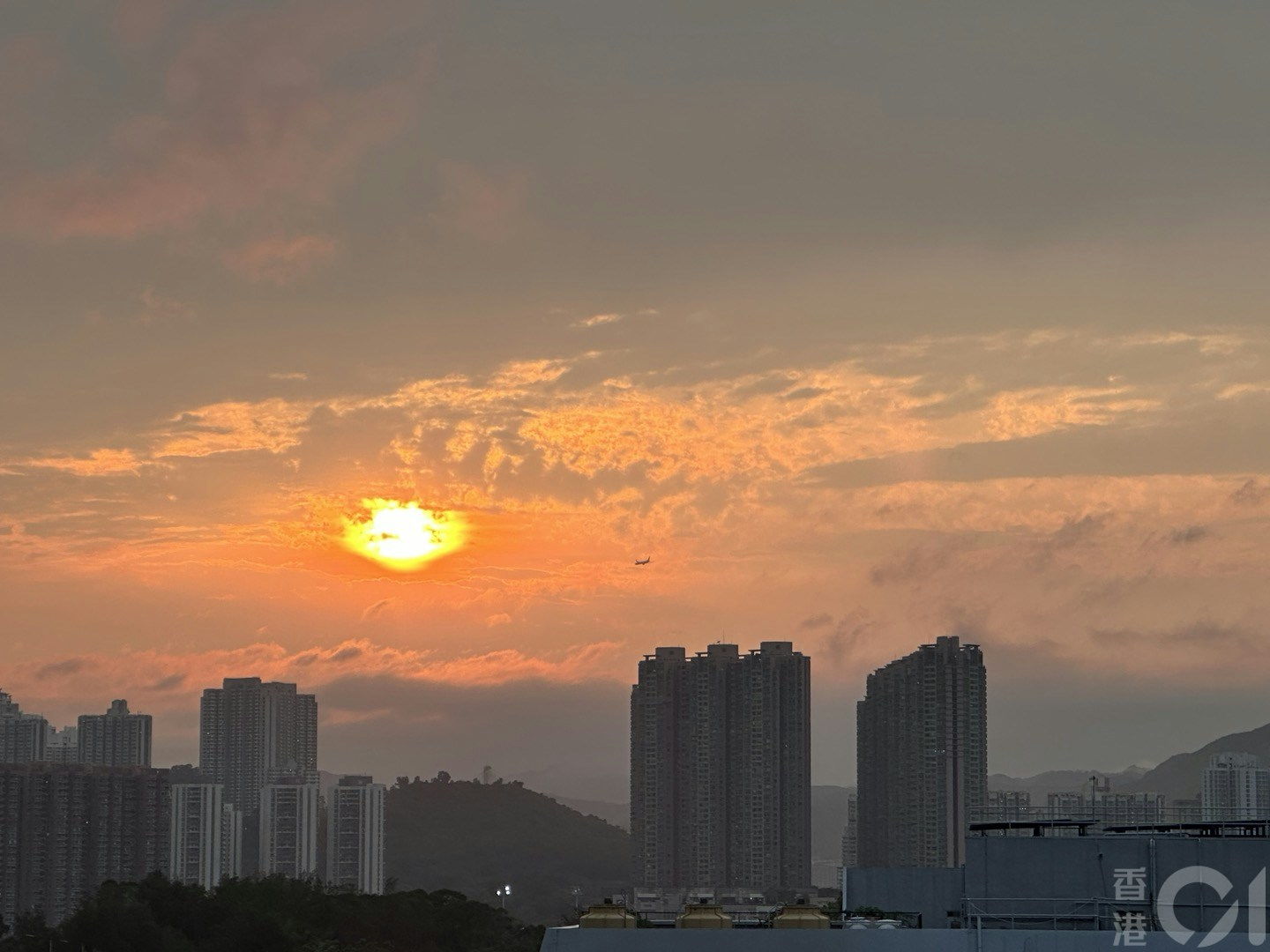 5月1日黃昏時間，短暫重見太陽，夕陽變成鹹蛋黃徐徐落下。（倪清江攝）