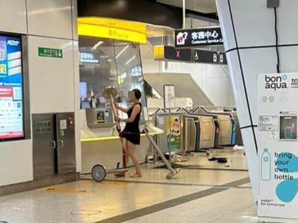 本港网络疯传1组照片，见到观塘港铁站内有1名短裙女持排队栏杆不断攻击票务站。（图片来源：「车干」）