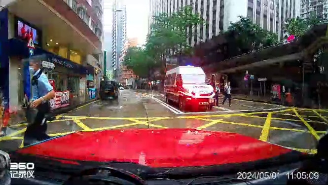 两名警员下车了解伤者情况，其中一人跑过马路。（Bosco Chu／香港突发事故报料区）