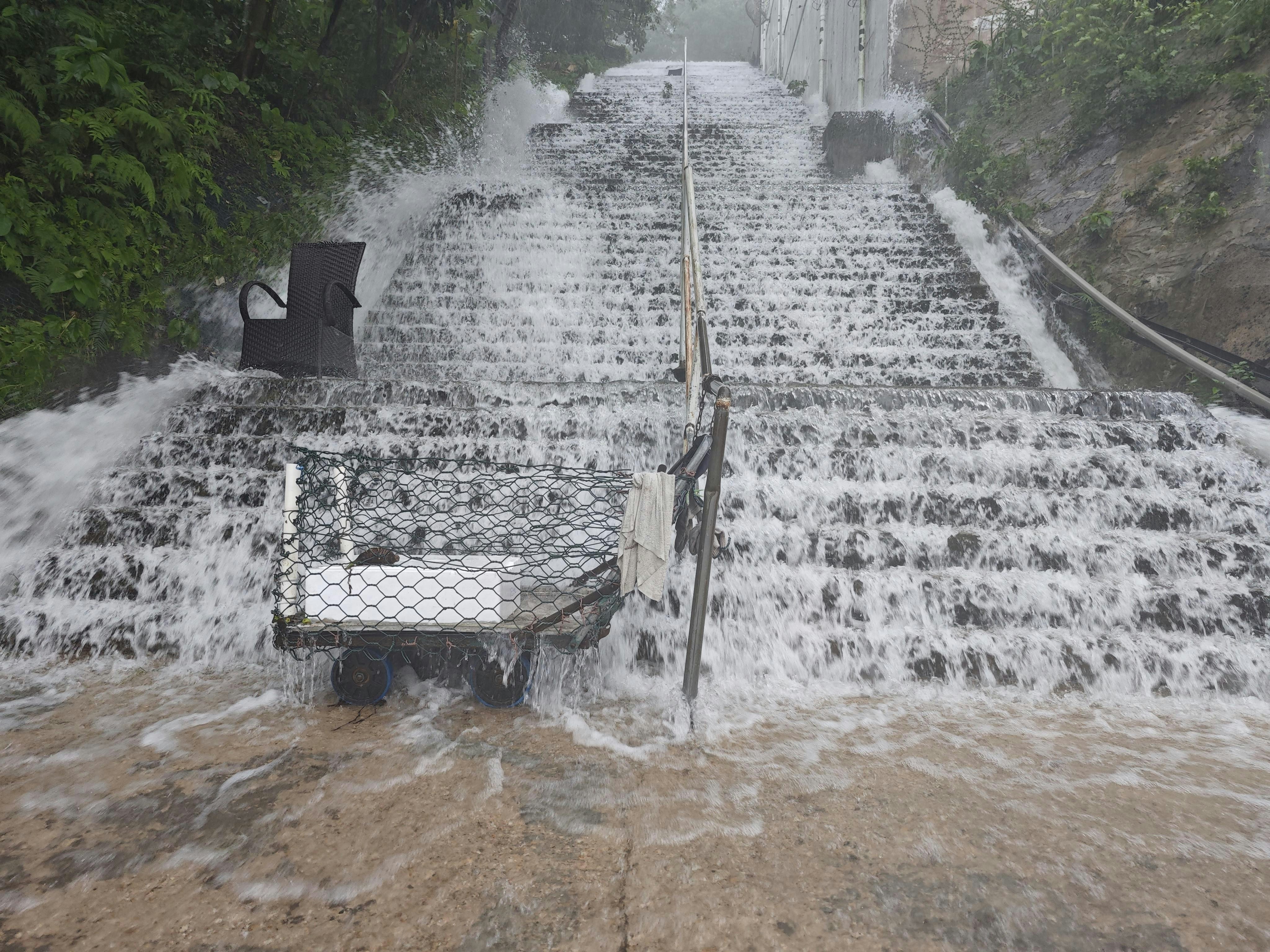清水湾银岬路一条楼楼梯，雨水如瀑布泻下。