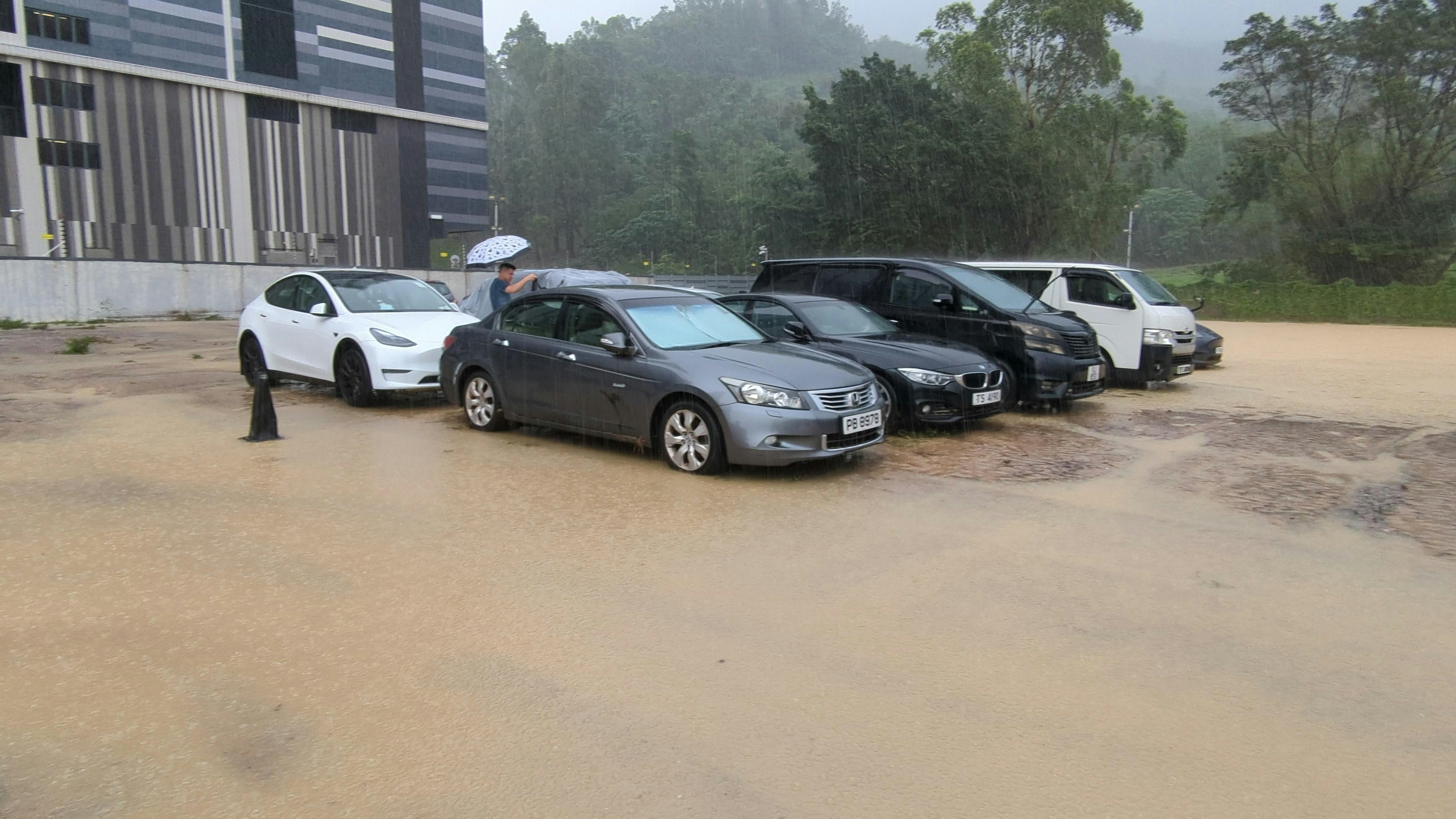 雨势稍为缓和，停车场的积水逐渐减退。（黄伟民摄）