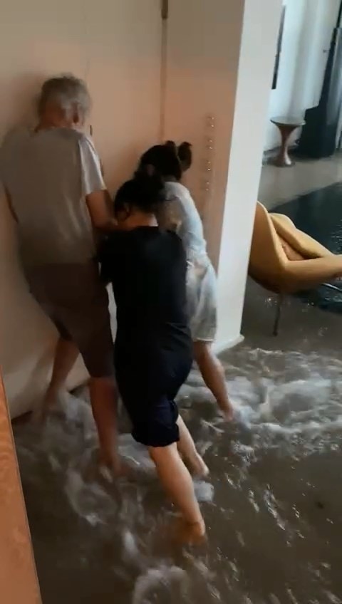 本港网络疯传影片，指暴雨下西贡有价值数千万元豪宅不断入水，而屋内一家人一同挡着大门。（影片截图）