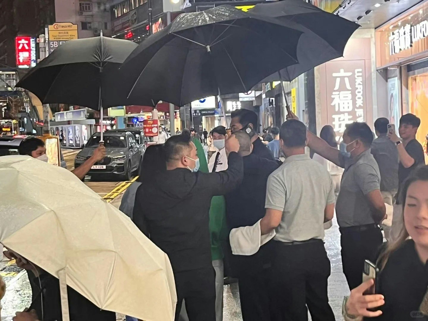 古天乐身旁的大刘与甘比被雨伞阵包围。(小红书)
