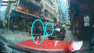 接应私家车停在宜昌街路边，一名男子站在车旁「手指指」向女事主的方向，一名穿深色衣裤、白波鞋及戴cap帽男子随即走近。（片段截图）