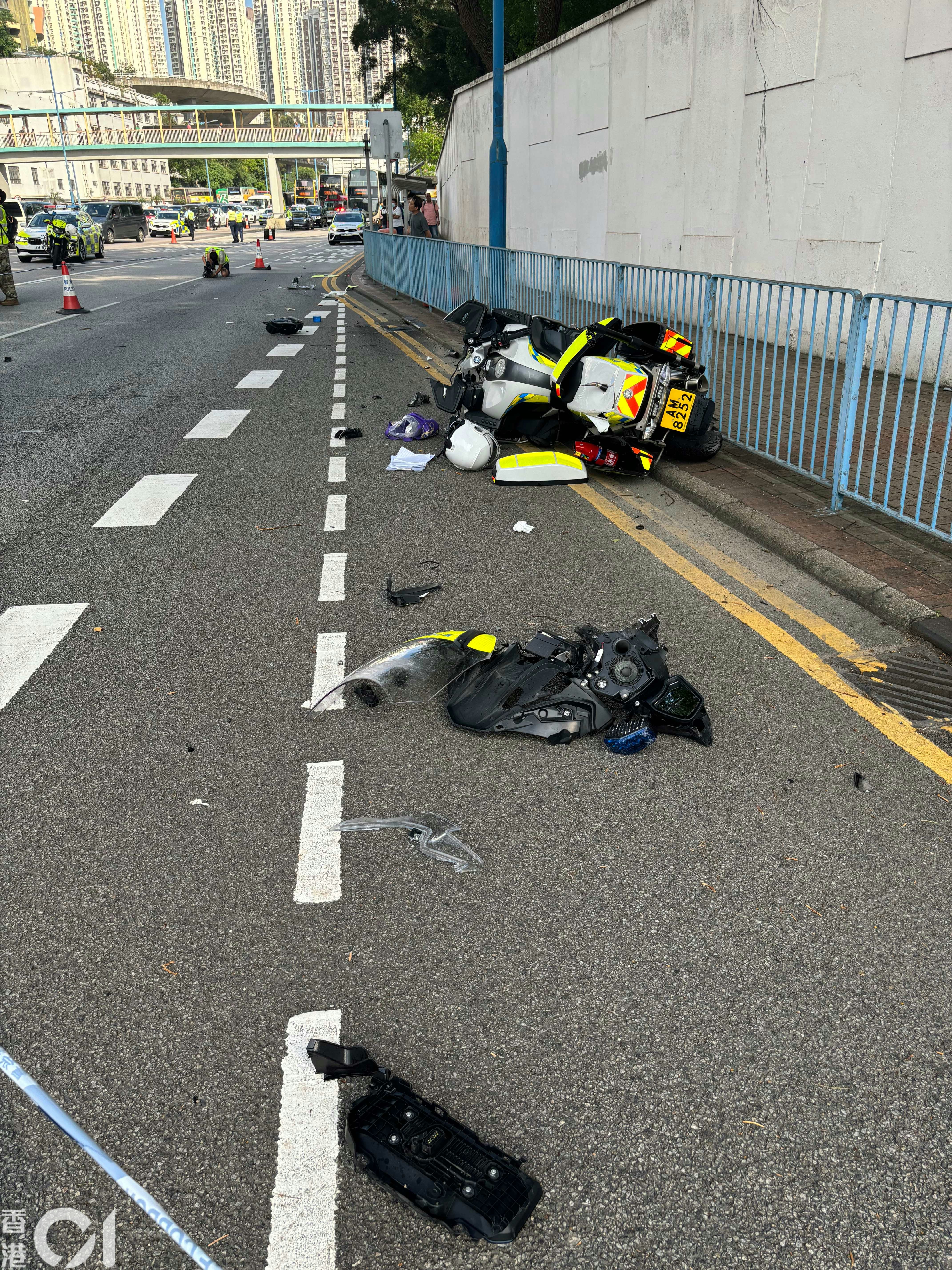 一辆私家车与一辆警察电单车在观塘道相撞，警察电单车零件散落一地。（罗日升摄）