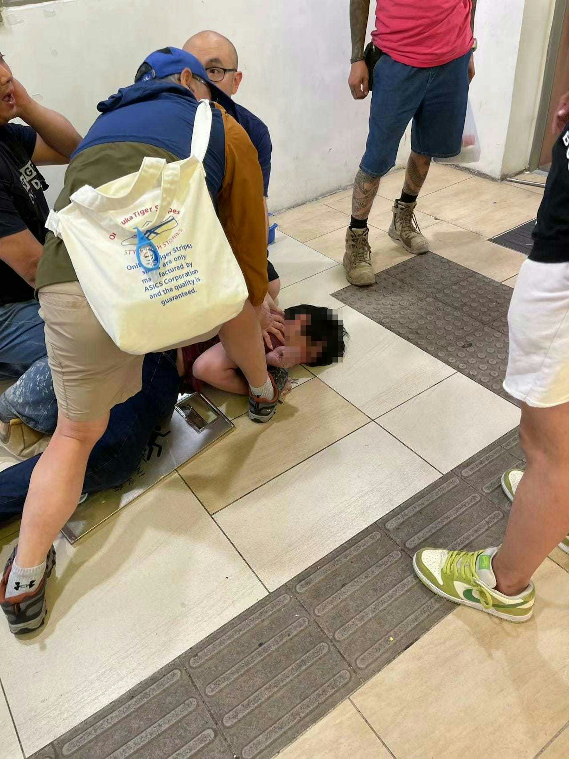 持刀男子於便利店對開被途人制服,再交由警員處理。(讀者提供)