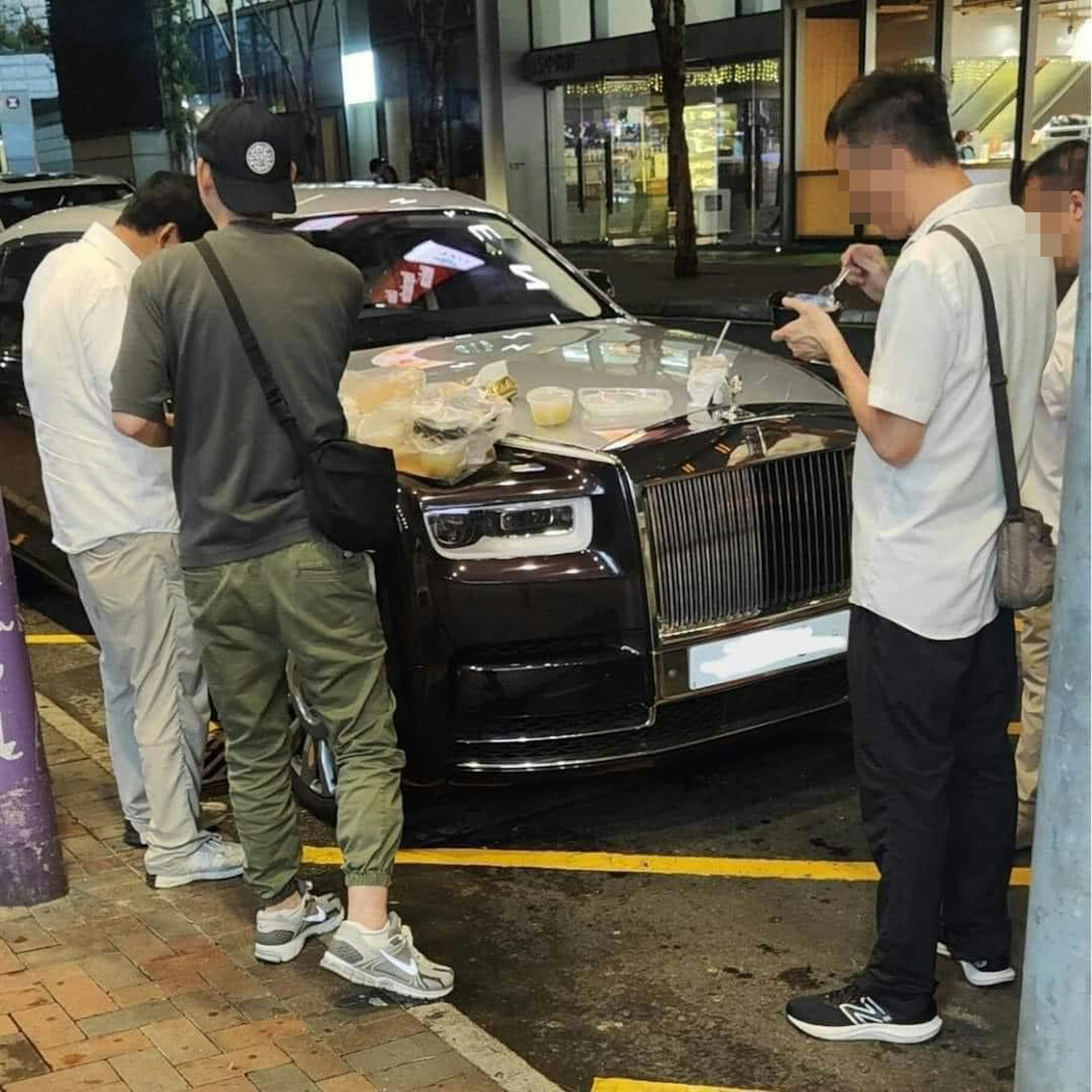 有停泊於尖沙咀的豪車勞斯萊斯,車頭冚被數男子當作餐枱「開餐」。(FB「大埔 TAI PO」圖片) 有停泊於尖沙咀的豪車勞斯萊斯,車頭冚被數男子當作餐枱「開餐」。(FB「大埔 TAI PO」圖片)
