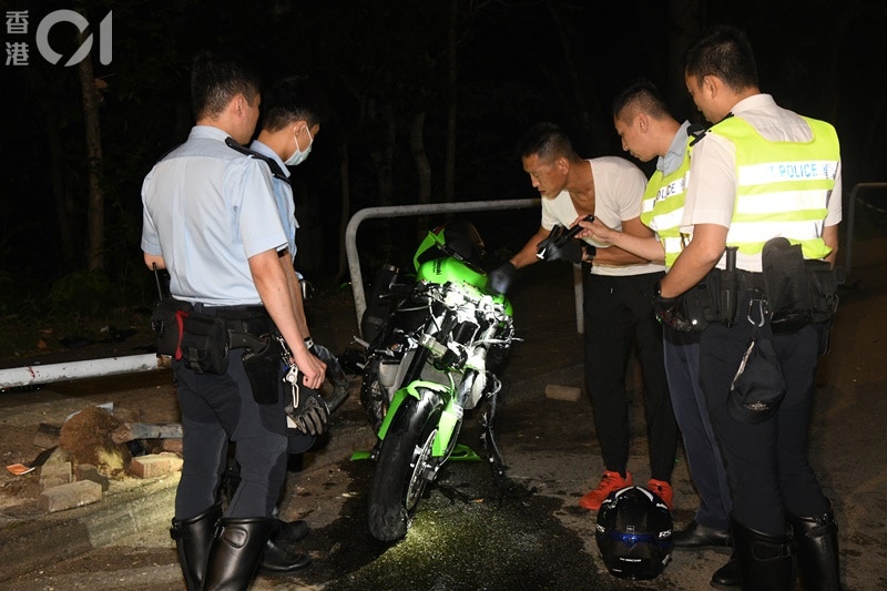 電單車將鐵欄撞至「連根拔起」，司機身亡乘客傷。現場留下死傷者的遺物，包括頭盔等。警方在場調查。