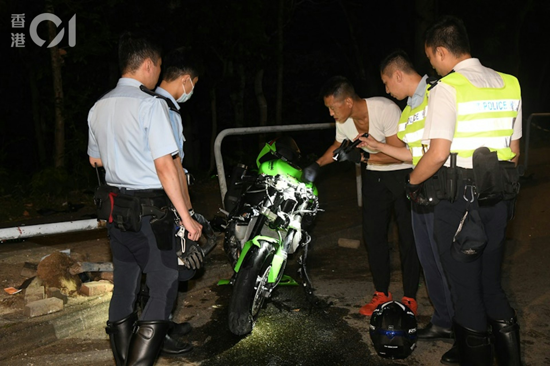 電單車將鐵欄撞至「連根拔起」,司機身亡乘客傷。現場留下死傷者的遺物,包括頭盔等。警方在場調查。