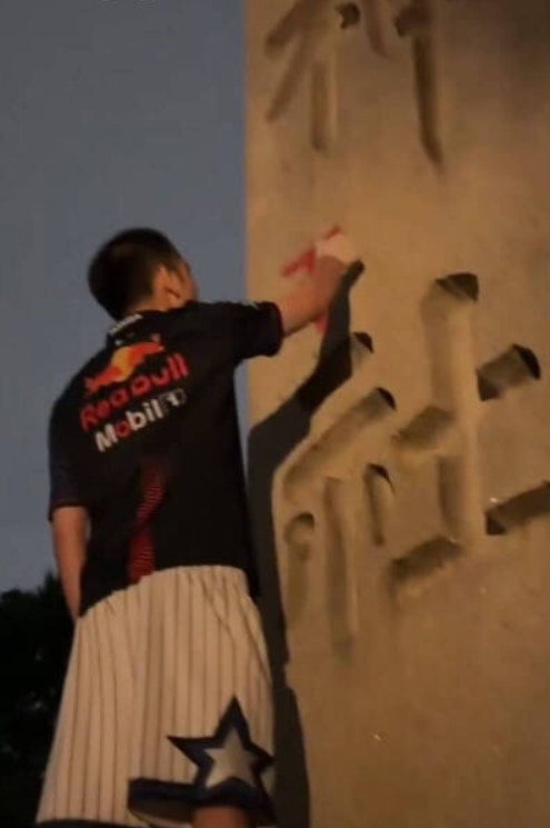 影片可見「鐵頭」爬上靖國神社入口處一根刻有「靖國神社」四字的石柱,向石柱撒尿,之後用紅色噴漆在石柱上寫上英文「Toilet」(廁所),然後離去。(影片截圖) 影片可見「鐵頭」爬上靖國神社入口處一根刻有「靖國神社」四字的石柱,向石柱撒尿,之後用紅色噴漆在石柱上寫上英文「Toilet」(廁所),然後離去。(影片截圖)