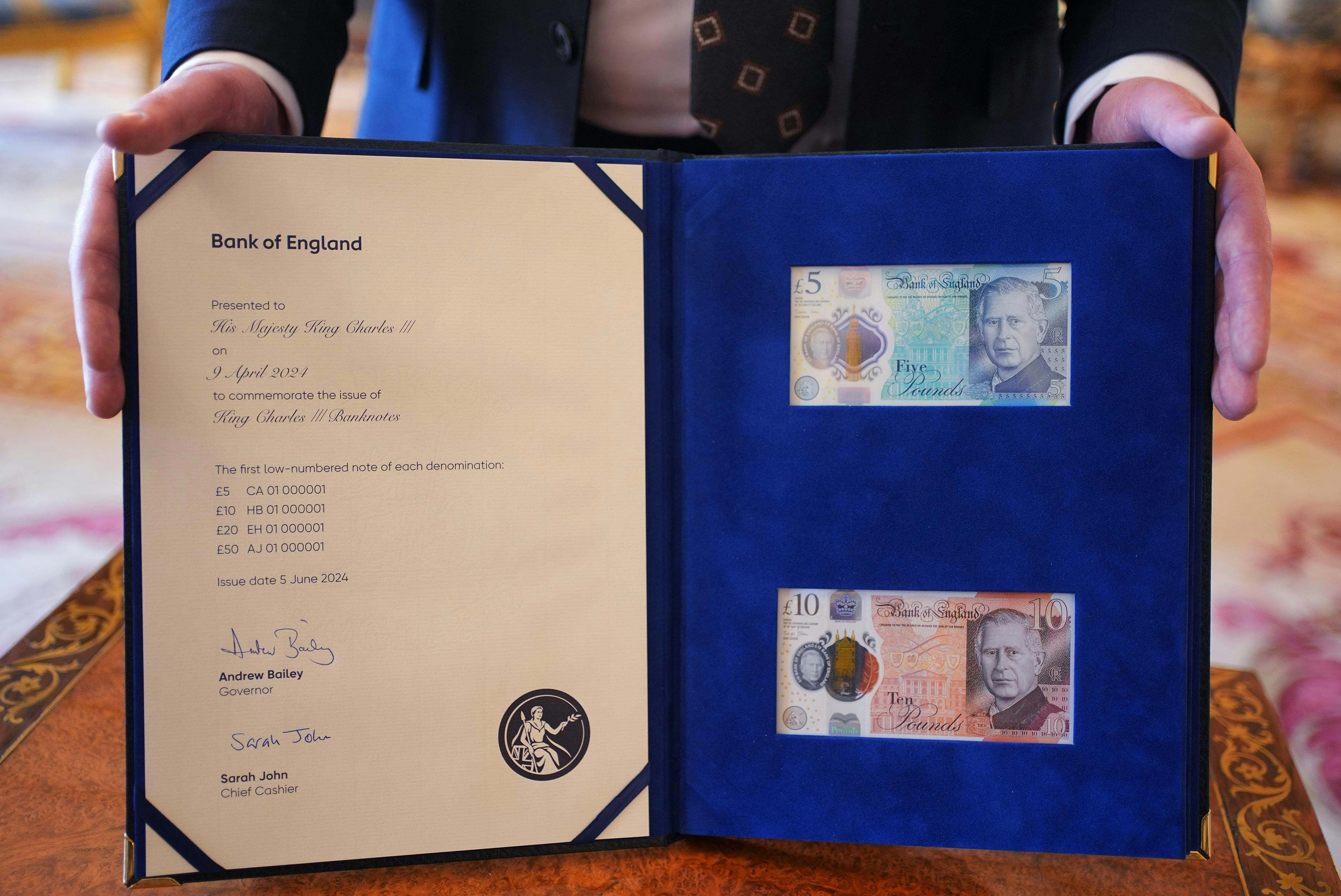 圖為2024年4月9日，英倫銀行行長貝利在白金漢宮展示印有英王查理斯三世肖像的5及10英鎊紙幣。（Getty Images）