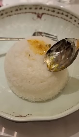 有網民到茶餐廳用餐，發現白飯就算用匙羹反復敲打或用叉插，也未能被戳開。（「香港茶餐廳及美食關注組」FB影片截圖）