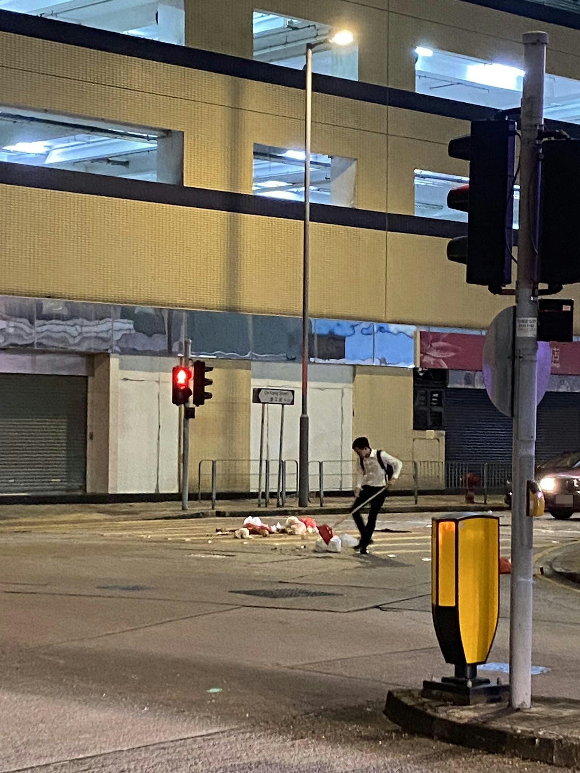 身穿白色襯衫和黑色西裝長褲的港男取起掃把,走出馬路掃走垃圾,動作顯得優雅,仿如跳舞。(facebook群組「To Kwa Wan 土瓜灣之友」圖片) 身穿白色襯衫和黑色西裝長褲的港男取起掃把,走出馬路掃走垃圾,動作顯得優雅,仿如跳舞。(facebook群組「To Kwa Wan 土瓜灣之友」圖片)