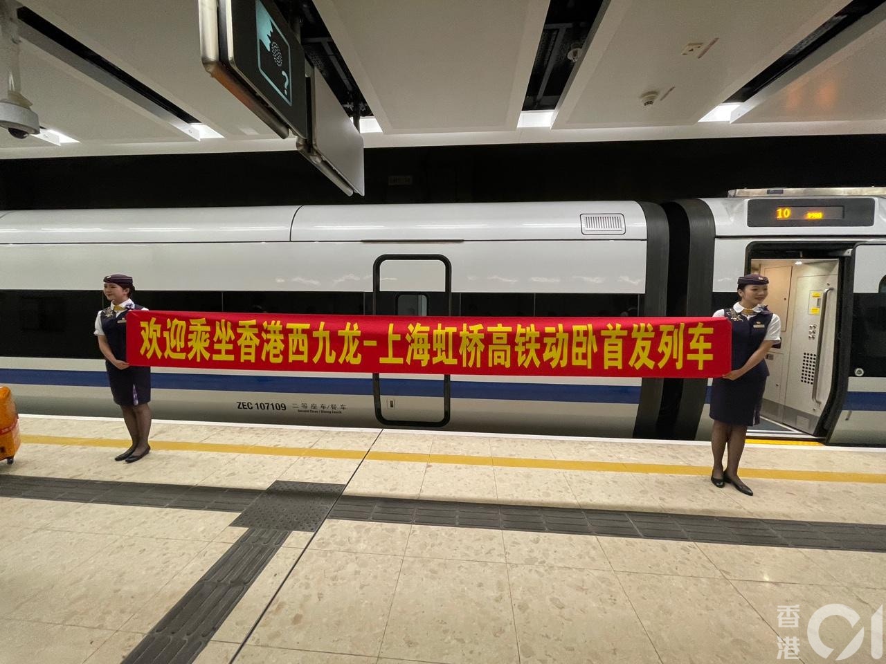 6月15日，高铁西九龙站开往上海的动卧列车启程，月台上有站务人员手持红幅欢迎首发的乘客。（潘耀升摄）
