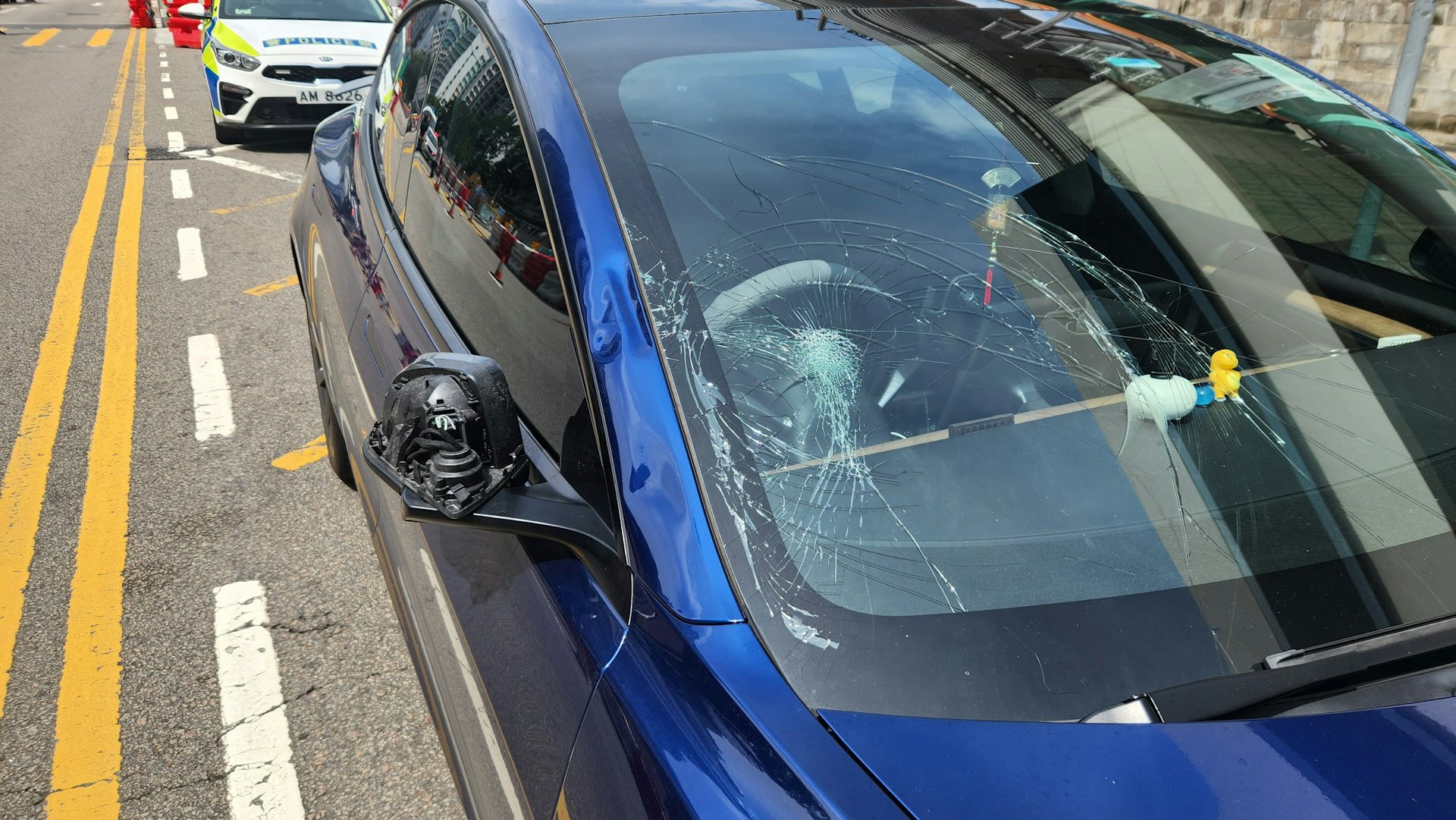 Tesla擋風玻璃、右邊側鏡及車身均有凹陷及損毀。