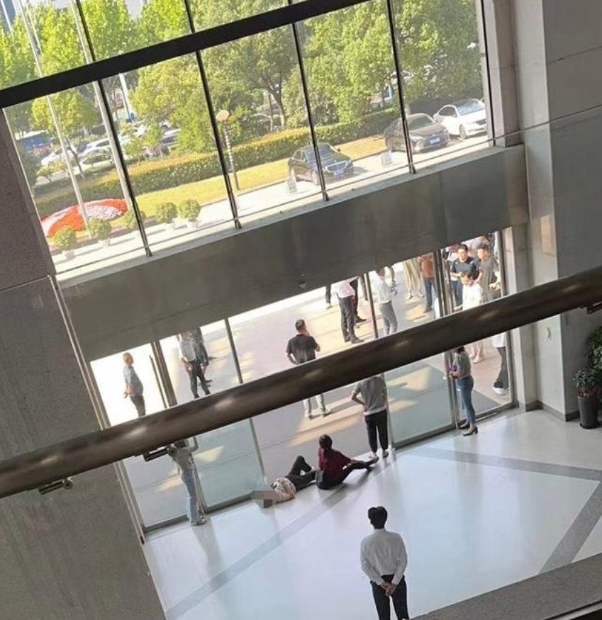 网传图片显示，18日早上有女子平躺在科大讯飞合肥总部大厅的玻璃门前，导致众多员工聚集在门外，无法进入公司。（百姓关注）