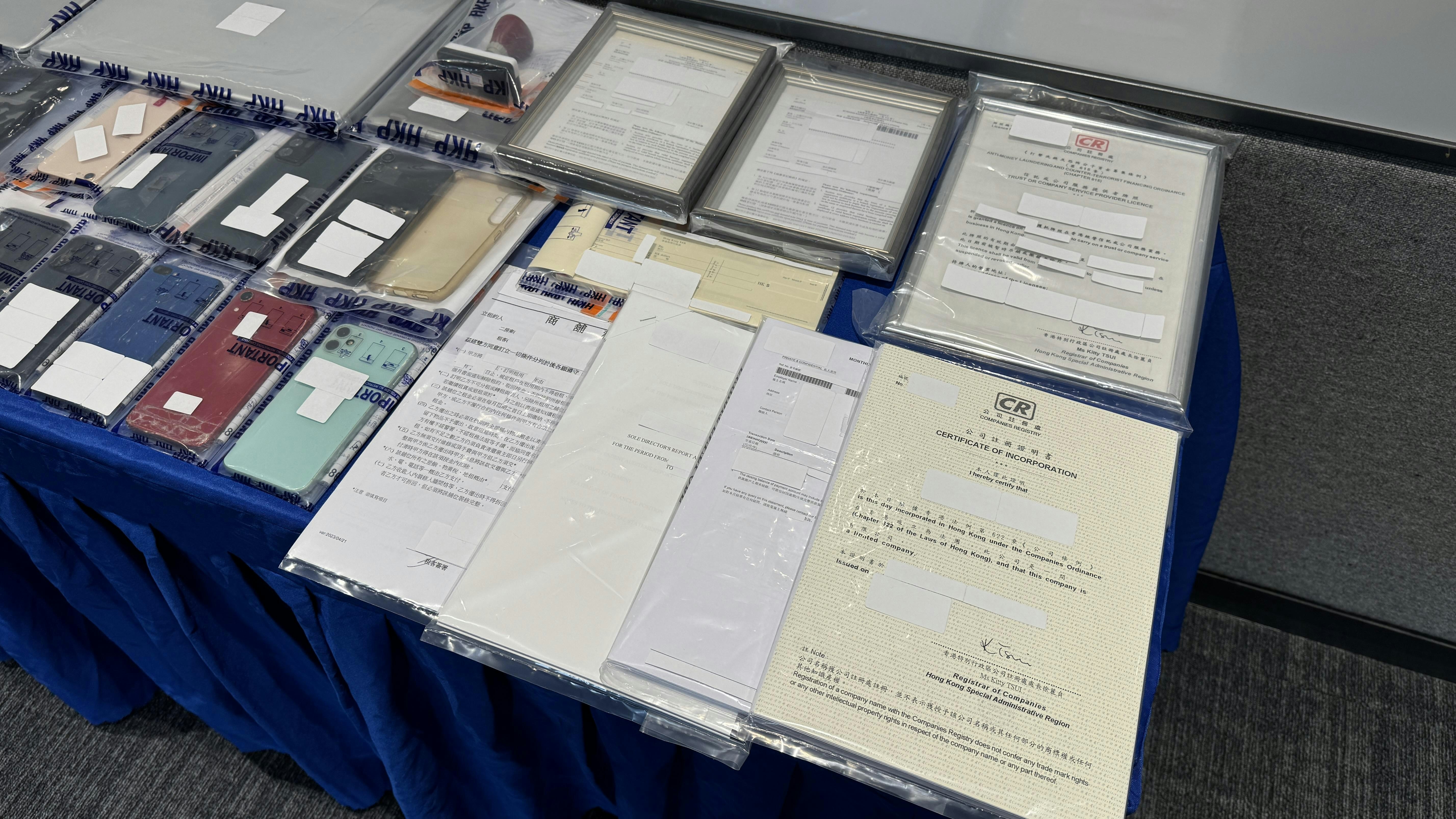 警方檢獲大量銀行文件、電子設備、銀行卡及部分現金。（翁鈺輝攝）