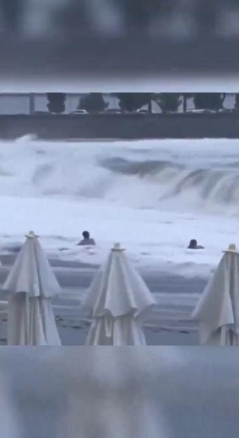 2人在水中挣扎，一度牵手想返回岸上，却再被海浪冲跌，女子来不及站起来之际，已被另一阵巨浪卷走。（影片截图）