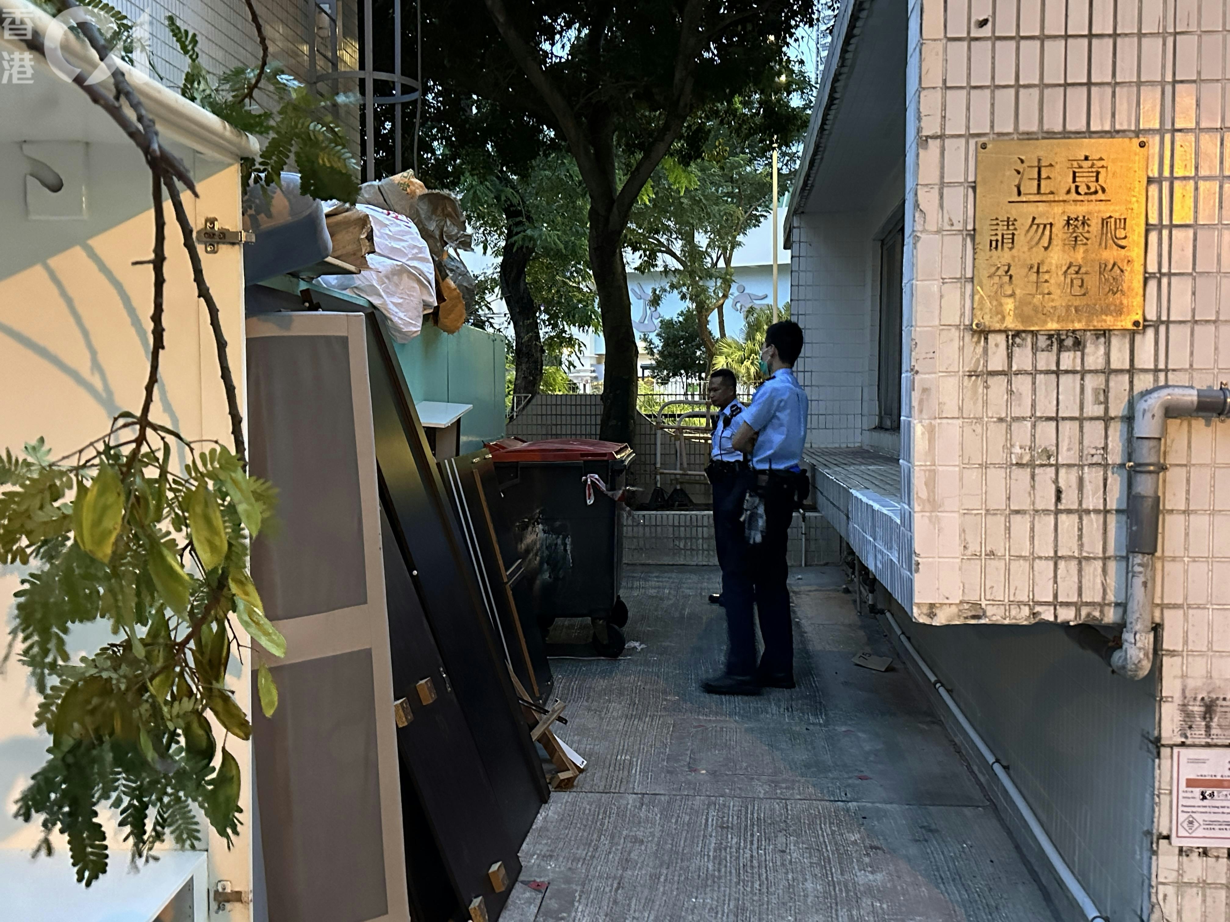 粉岭华心邨华勉楼发生命案，警员看守大厦旁一个垃圾场。（王译扬摄）