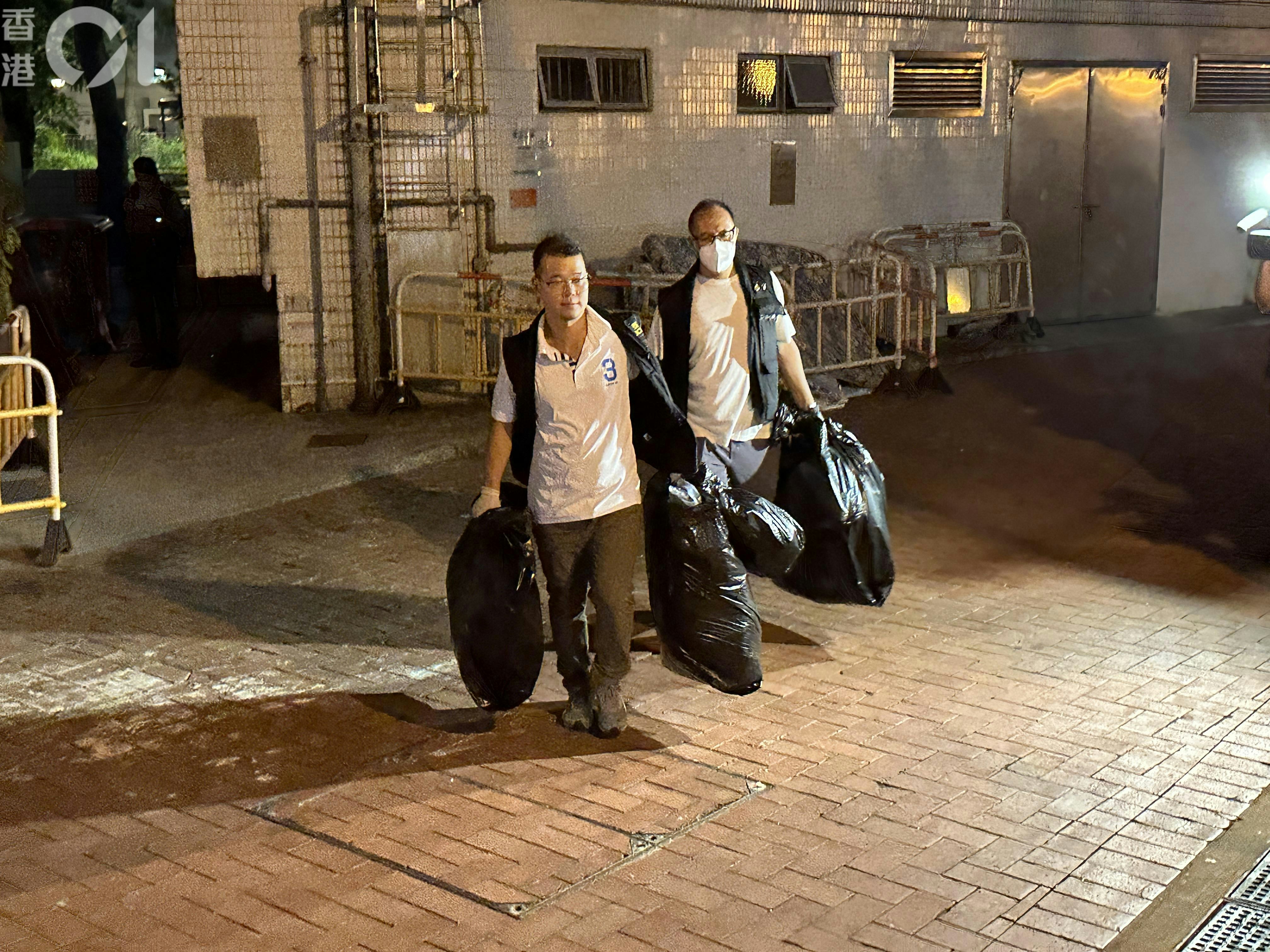 探员在大厦旁一个垃圾桶内，检走床单、衣服等杂物，并带上涉案单位调查。（王译扬摄）